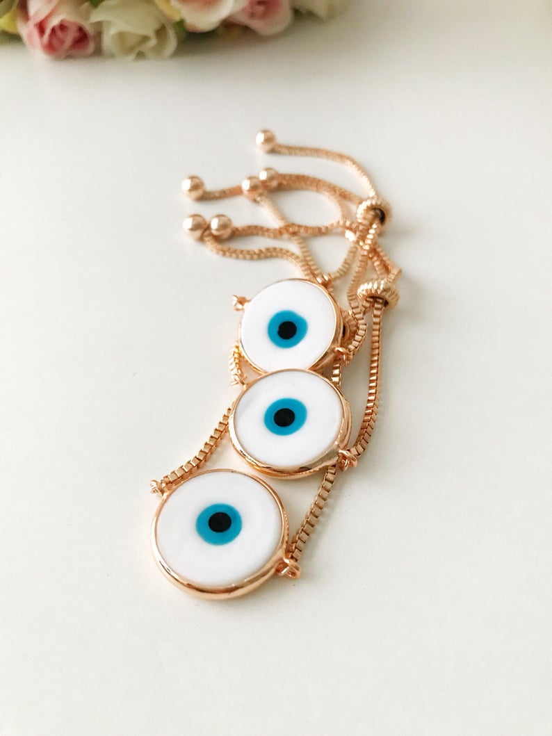 A beautiful White Murano Evil Eye Bracelet featuring a handmade Murano glass charm on an adjustable rose gold chain, showcasing elegance and durability.