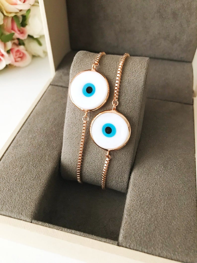 A beautiful White Murano Evil Eye Bracelet featuring a handmade Murano glass charm on an adjustable rose gold chain, showcasing elegance and durability.