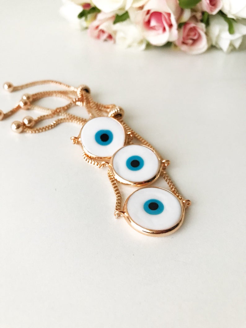 A beautiful White Murano Evil Eye Bracelet featuring a handmade Murano glass charm on an adjustable rose gold chain, showcasing elegance and durability.