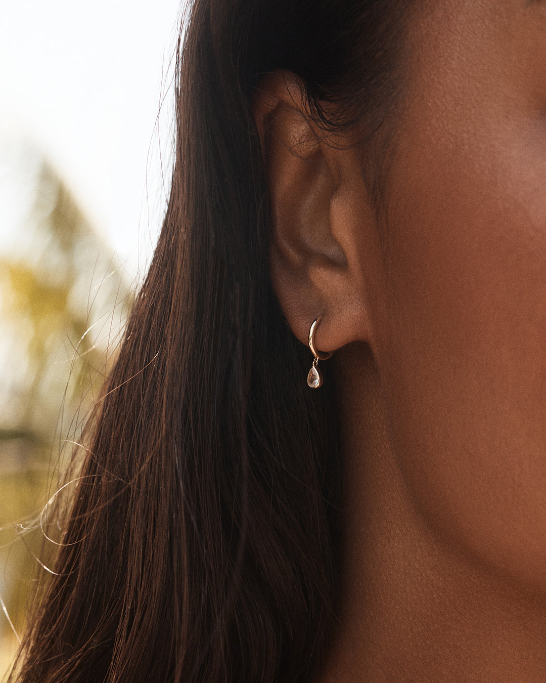 Elegant White Sapphire Pear Charm Huggies in 14k gold, showcasing a pear-shaped charm.