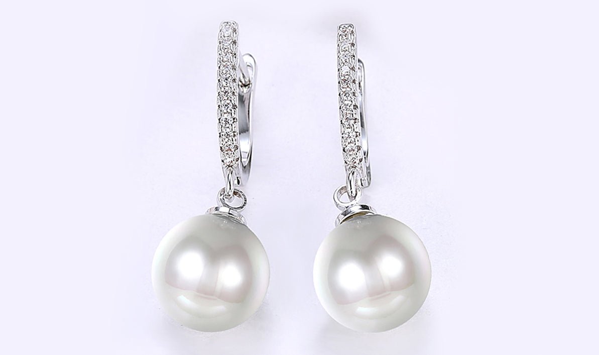 Elegant White Sapphire Thin Dangling Freshwater Pearl Clip On Earrings in 14K white gold plating, showcasing shimmering stones and pearls.