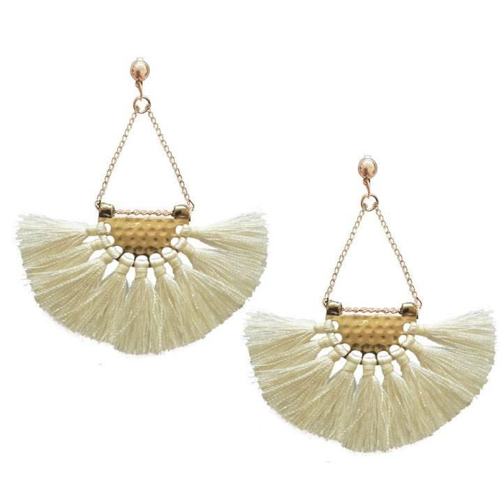 Elegant white tassel earrings hanging from a hammered-metal hoop, showcasing their stylish design and lightweight appeal.