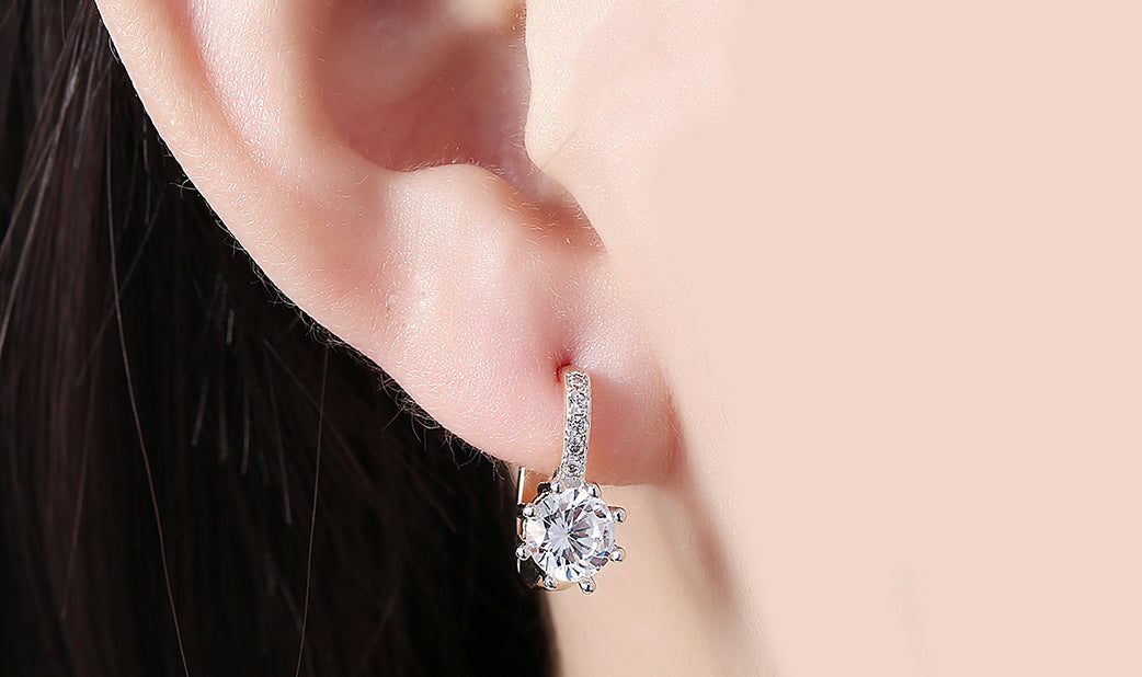 Elegant White Topaz 0.70 CT Round Huggie Earring in 18K White Gold Plated, showcasing its sparkling gemstone and luxurious finish.