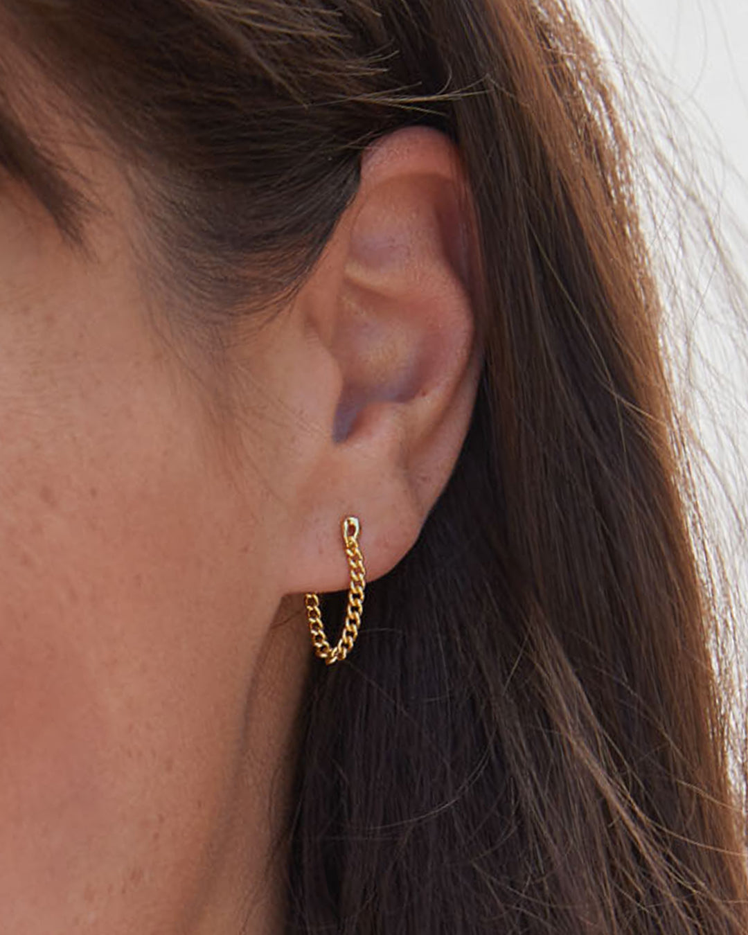 A pair of elegant Wilder Chain Huggies crafted from 14k gold, showcasing a delicate chain design.