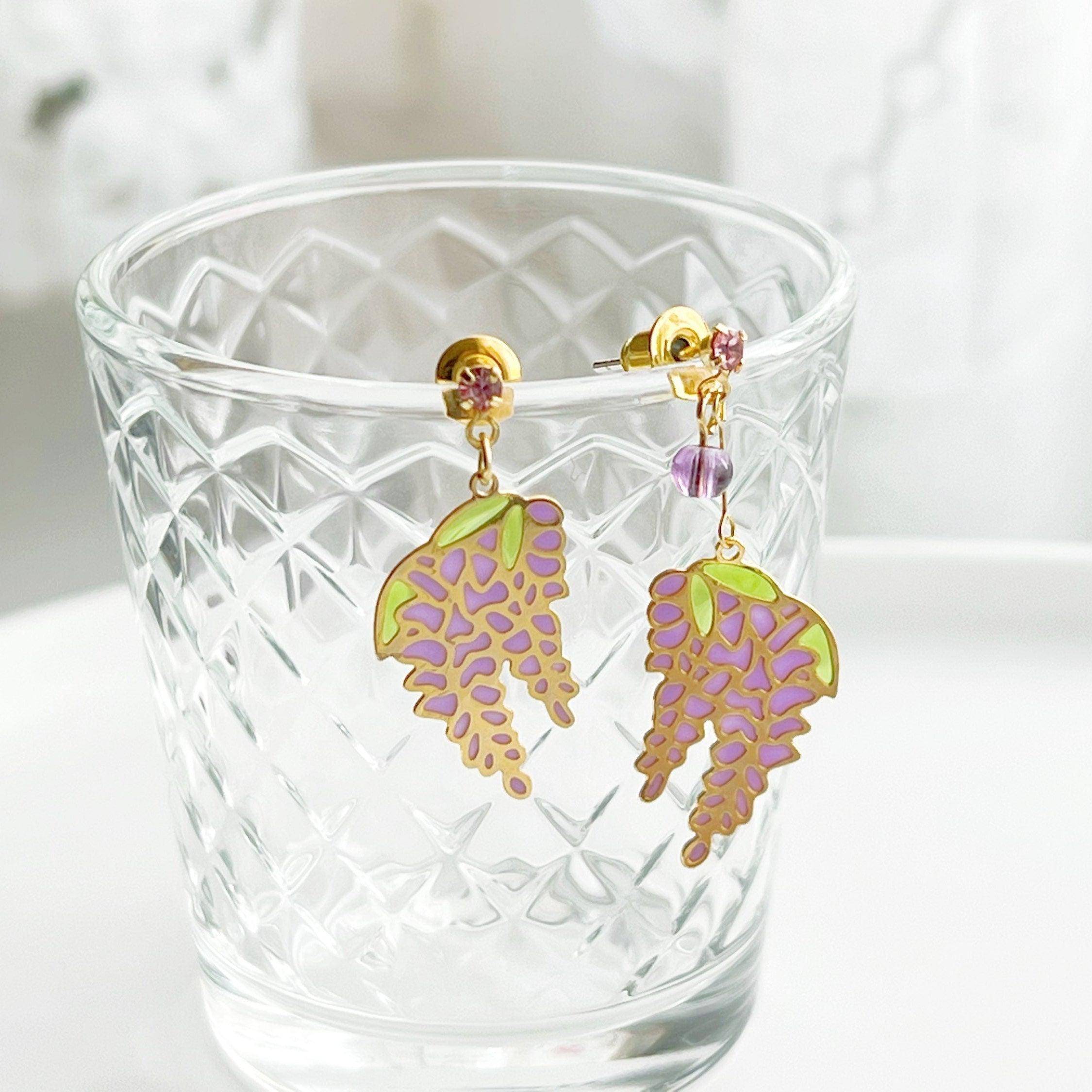Wisteria Earrings featuring purple flowers and leaves, crafted from sterling silver, gold plated bronze, and resin.
