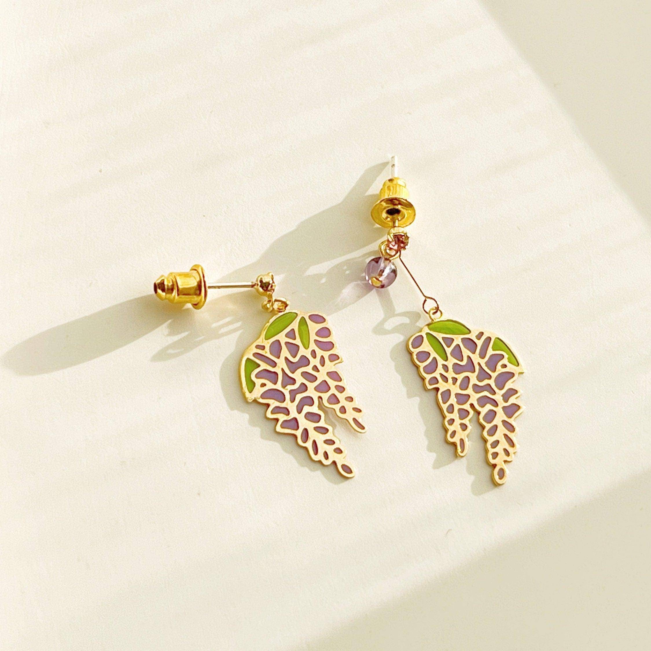 Wisteria Earrings featuring purple flowers and leaves, crafted from sterling silver, gold plated bronze, and resin.