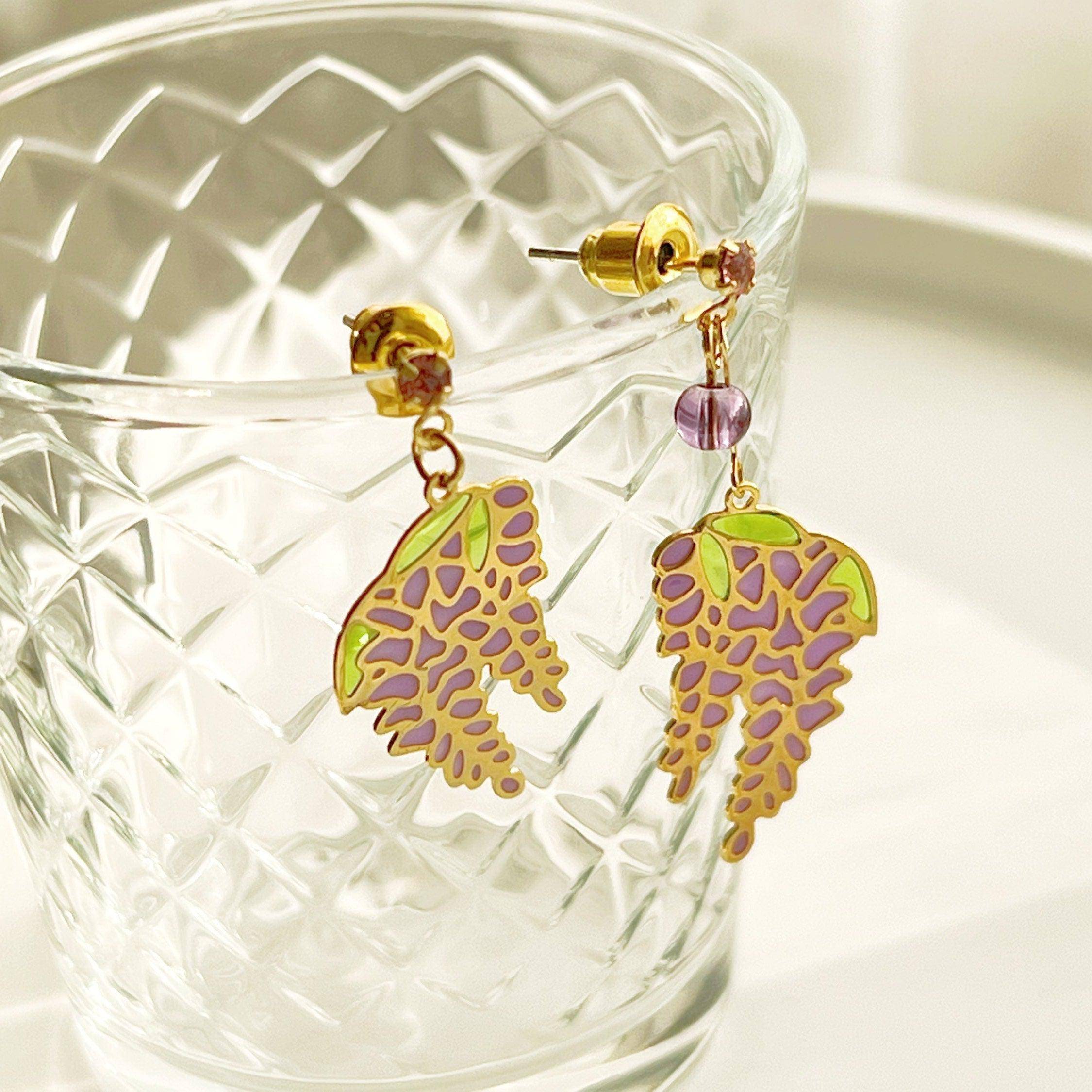 Wisteria Earrings featuring purple flowers and leaves, crafted from sterling silver, gold plated bronze, and resin.