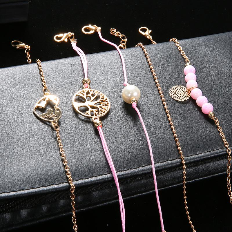 Women of The World Unite 5 Piece Bracelet Set featuring 14K gold plating, pink marble, filigree world pendant, and Tree of Life pendant.