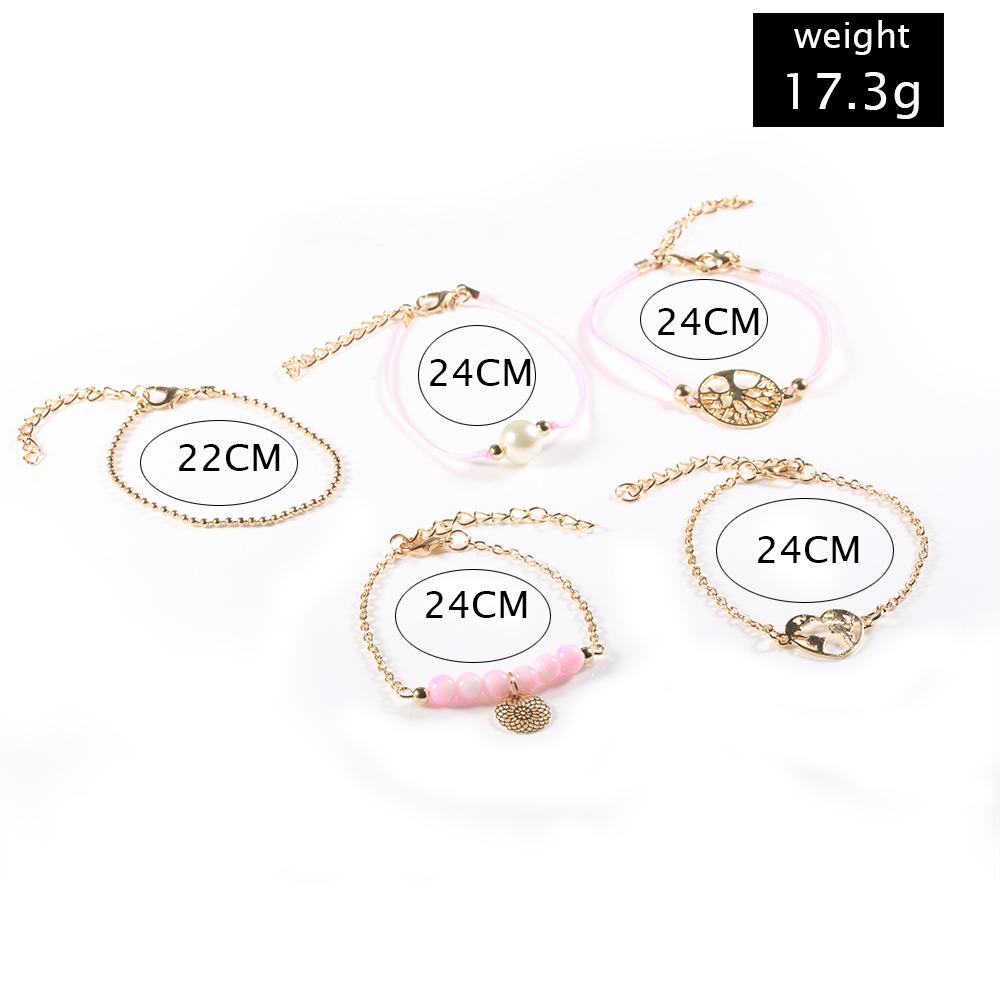 Women of The World Unite 5 Piece Bracelet Set featuring 14K gold plating, pink marble, filigree world pendant, and Tree of Life pendant.