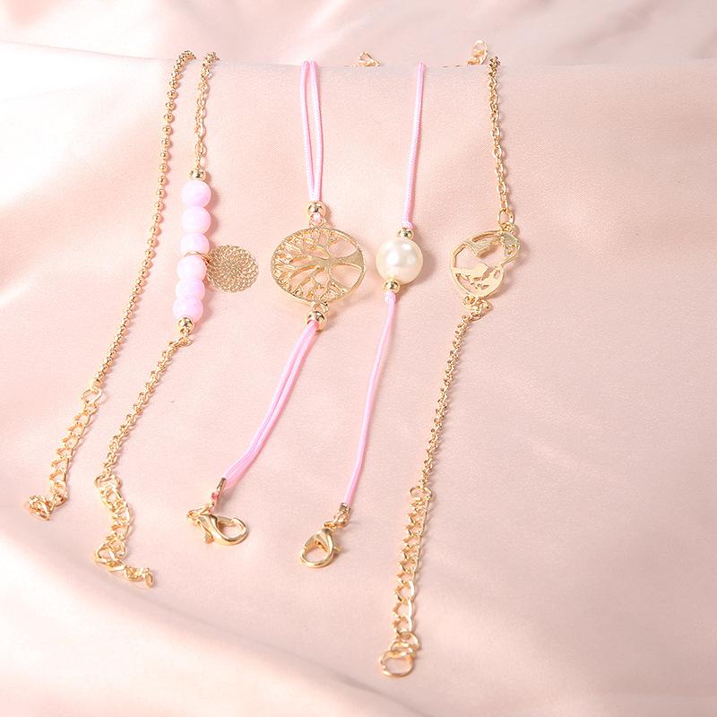 Women of The World Unite 5 Piece Bracelet Set featuring 14K gold plating, pink marble, filigree world pendant, and Tree of Life pendant.