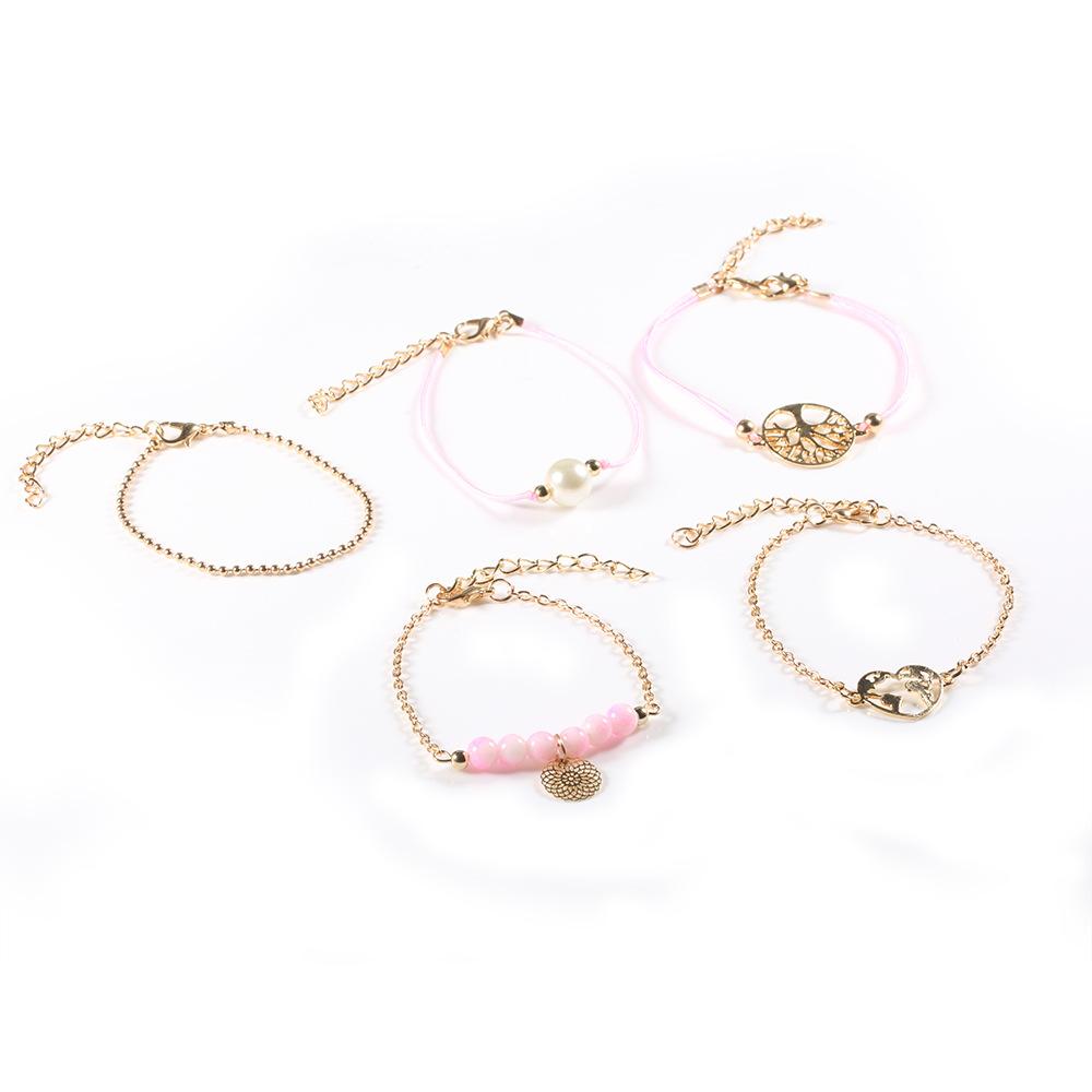 Women of The World Unite 5 Piece Bracelet Set featuring 14K gold plating, pink marble, filigree world pendant, and Tree of Life pendant.
