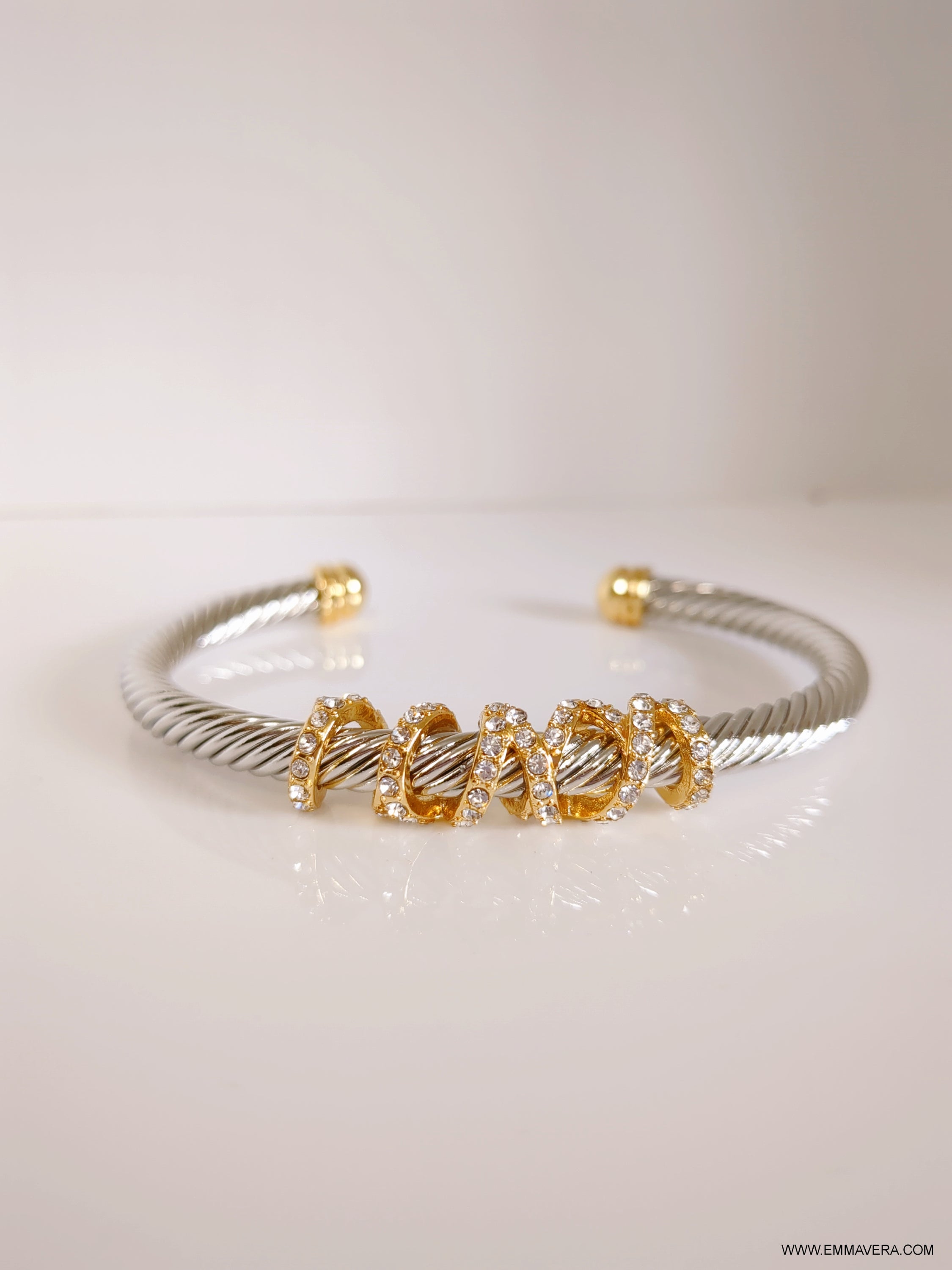 Wrap Around Crystal Bangle made of stainless steel with gold plating and simulated diamonds, showcasing its elegant design.