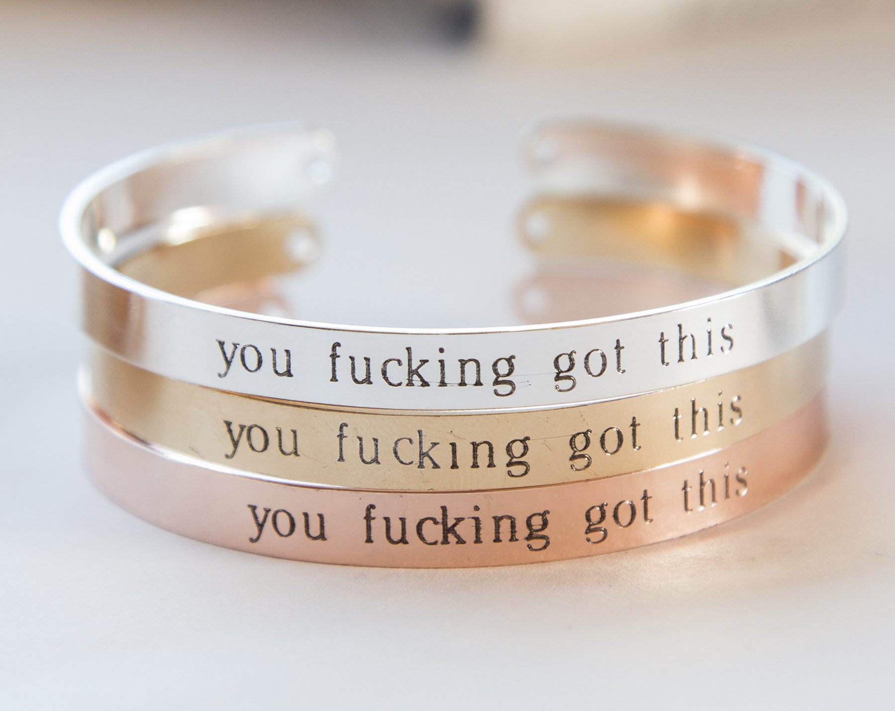 You Fucking Got This Bracelet in gold, rose gold, and silver plating, showcasing its adjustable design and inspirational engraving.