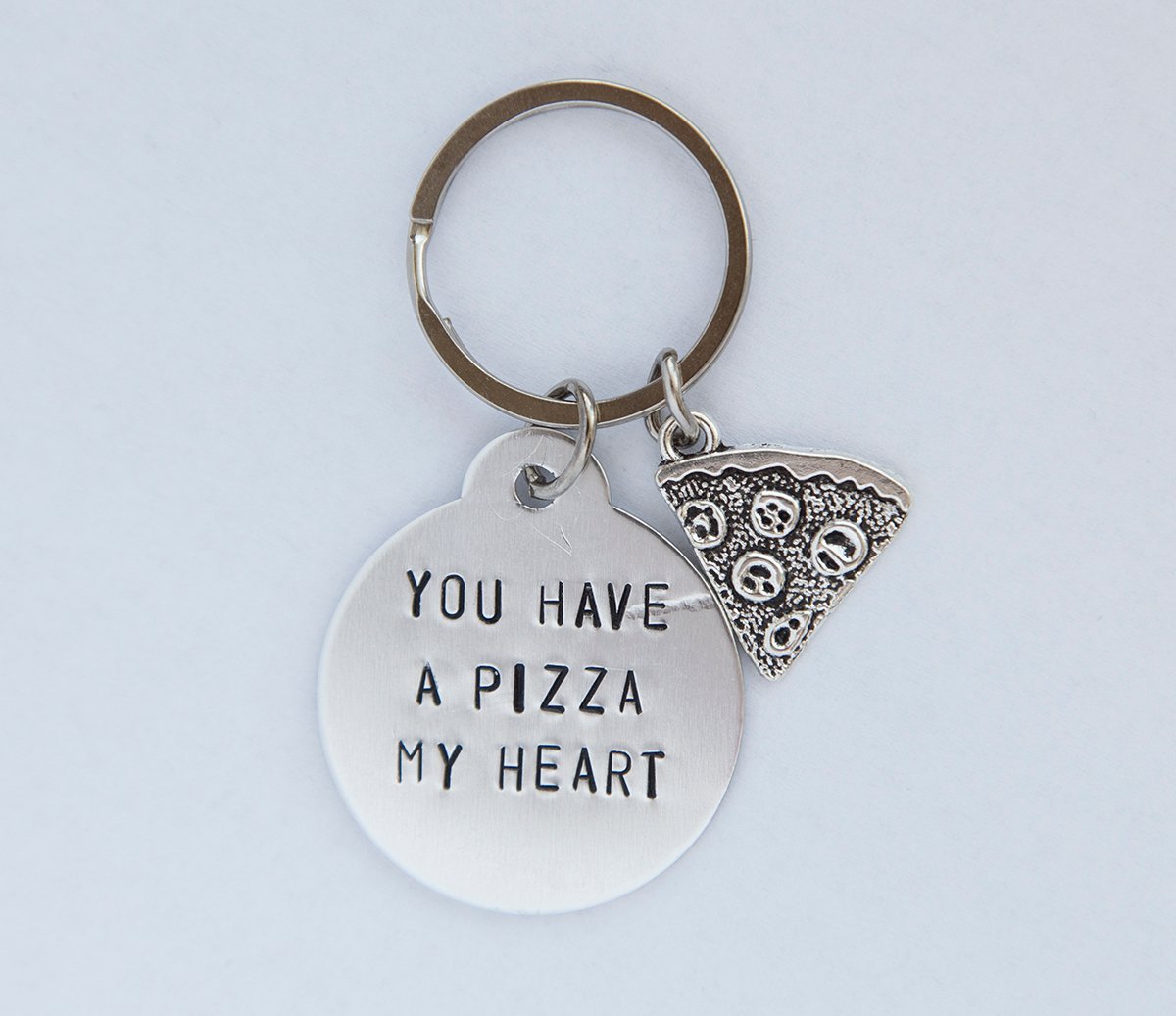 A hand-stamped stainless steel keychain with a round charm saying 'You have a pizza my heart', perfect for pizza lovers.