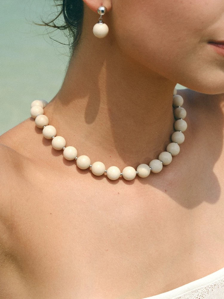 A beautiful Zen Harmony Tranquil White Fossil Necklace featuring natural white fossil stones, elegantly designed with 12mm beads.