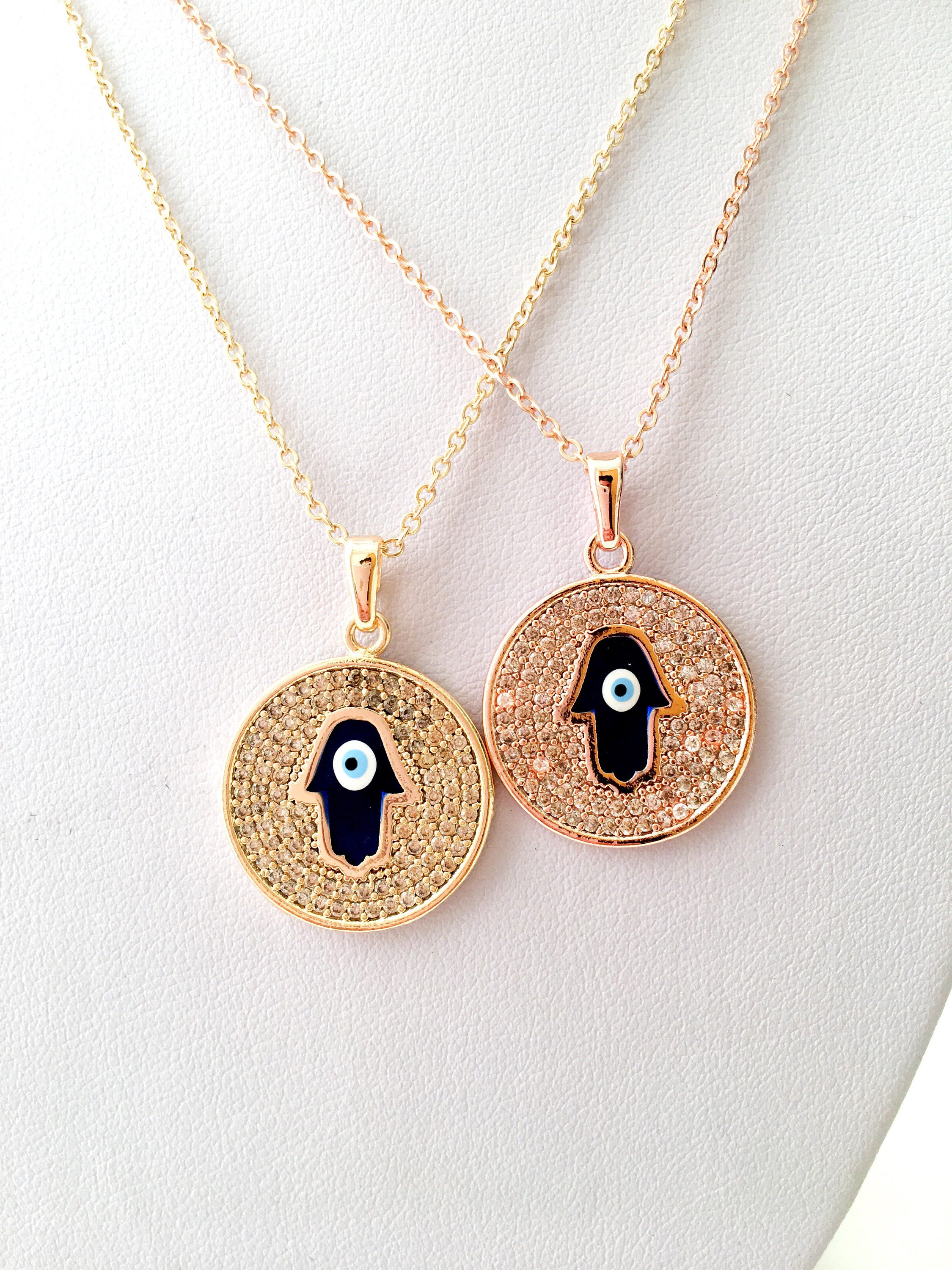 Zircon Evil Eye Necklace featuring a Hamsa Hand charm, available in gold and rose gold, showcasing intricate handmade craftsmanship.