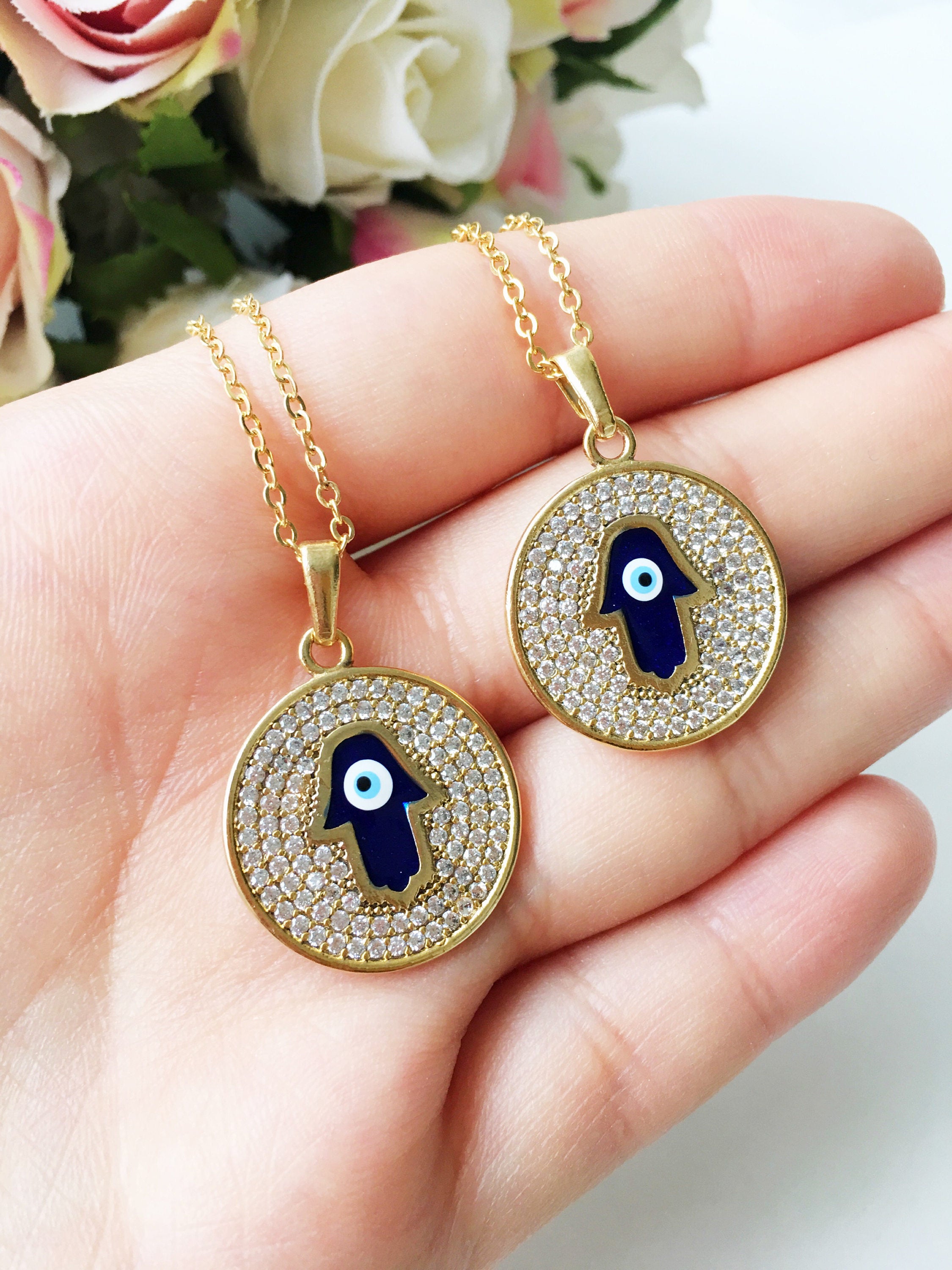 Zircon Evil Eye Necklace featuring a Hamsa Hand charm, available in gold and rose gold, showcasing intricate handmade craftsmanship.