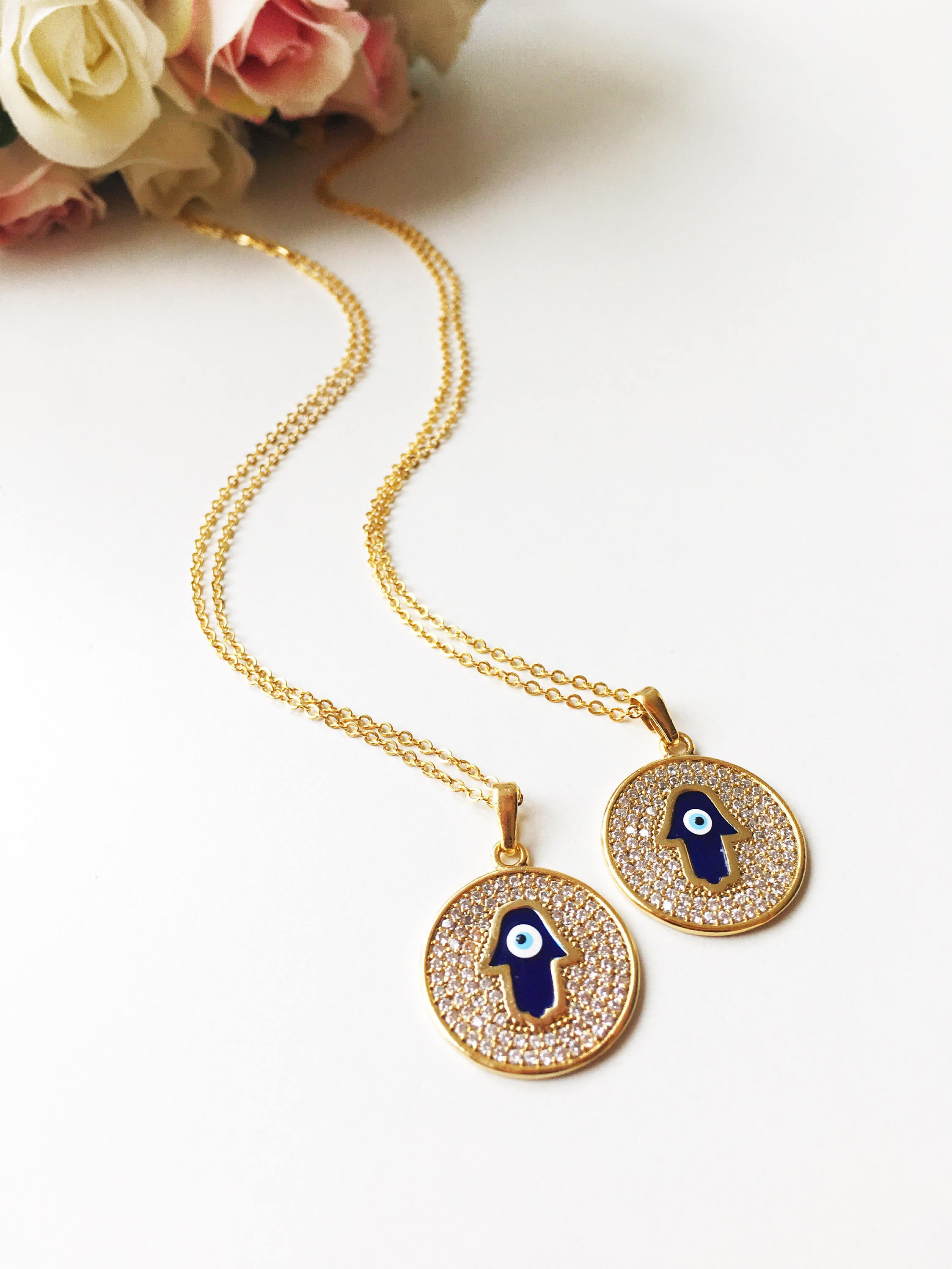 Zircon Evil Eye Necklace featuring a Hamsa Hand charm, available in gold and rose gold, showcasing intricate handmade craftsmanship.