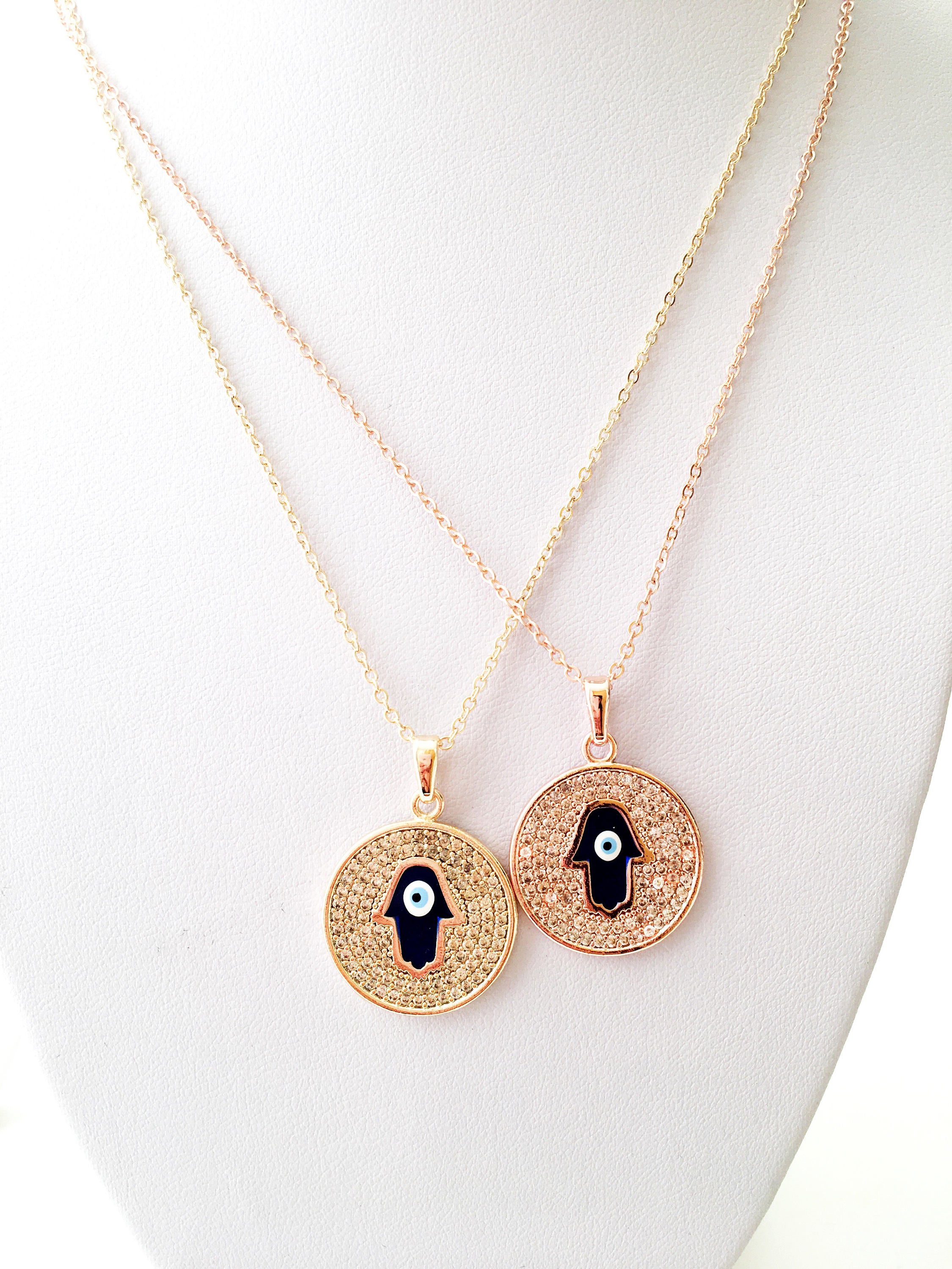 Zircon Evil Eye Necklace featuring a Hamsa Hand charm, available in gold and rose gold, showcasing intricate handmade craftsmanship.