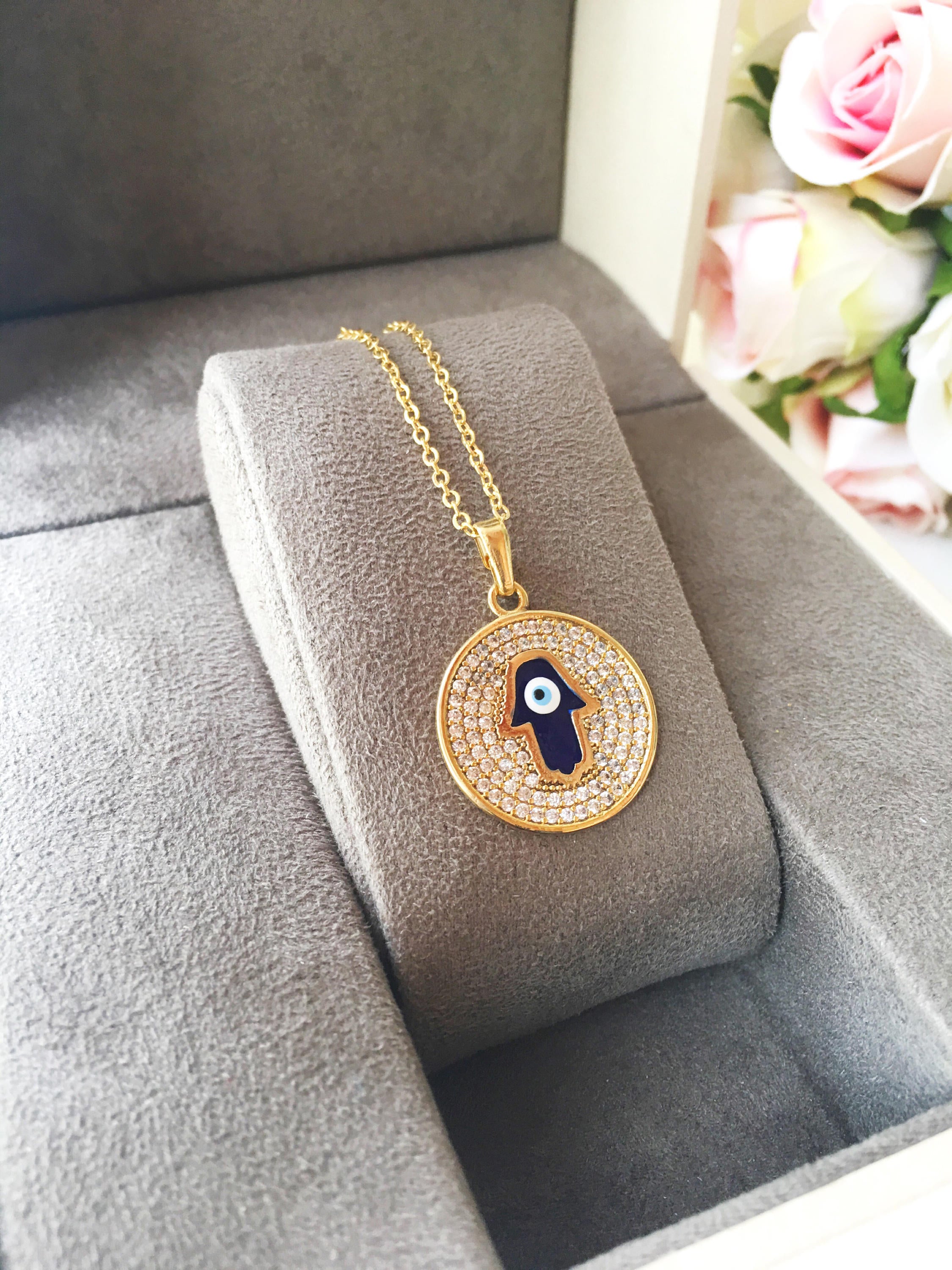 Zircon Evil Eye Necklace featuring a Hamsa Hand charm, available in gold and rose gold, showcasing intricate handmade craftsmanship.