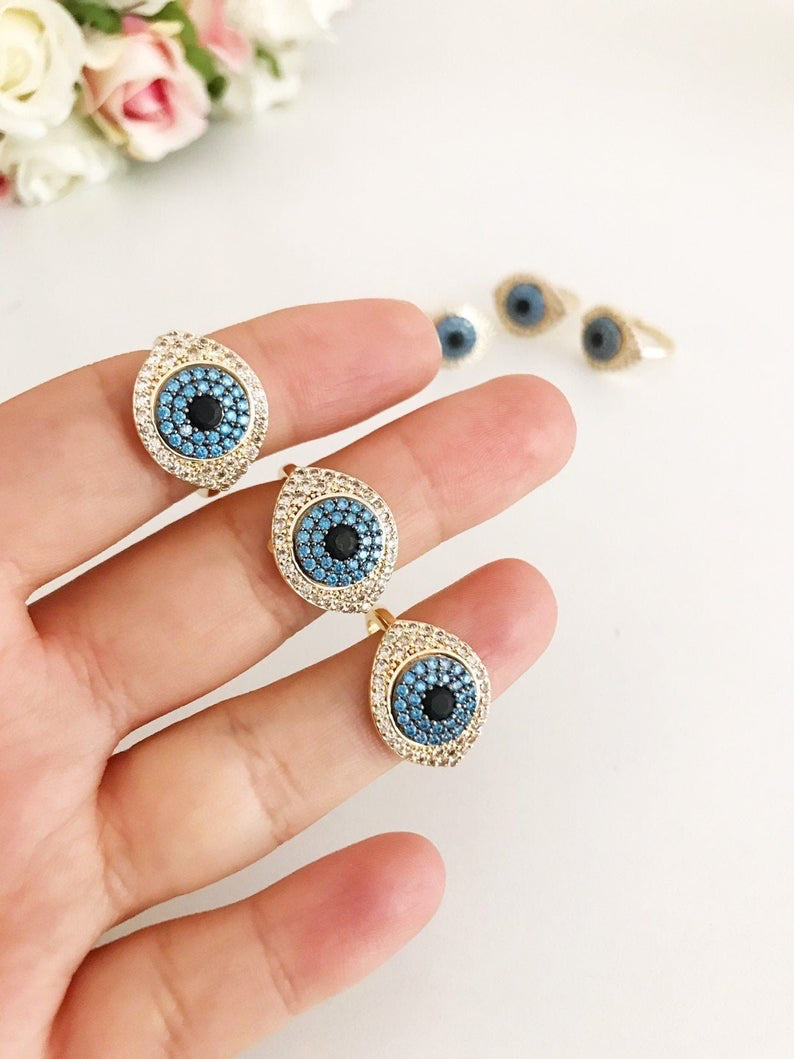 A stunning Zirconia Evil Eye Ring featuring a blue evil eye bead and sparkling zirconia stones, set in a gold adjustable band.