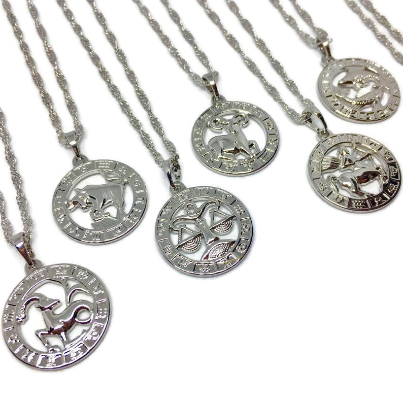 Zodiac Symbol Coin Necklace featuring a gold plated stainless steel pendant with astrological symbols, displayed on a delicate chain.
