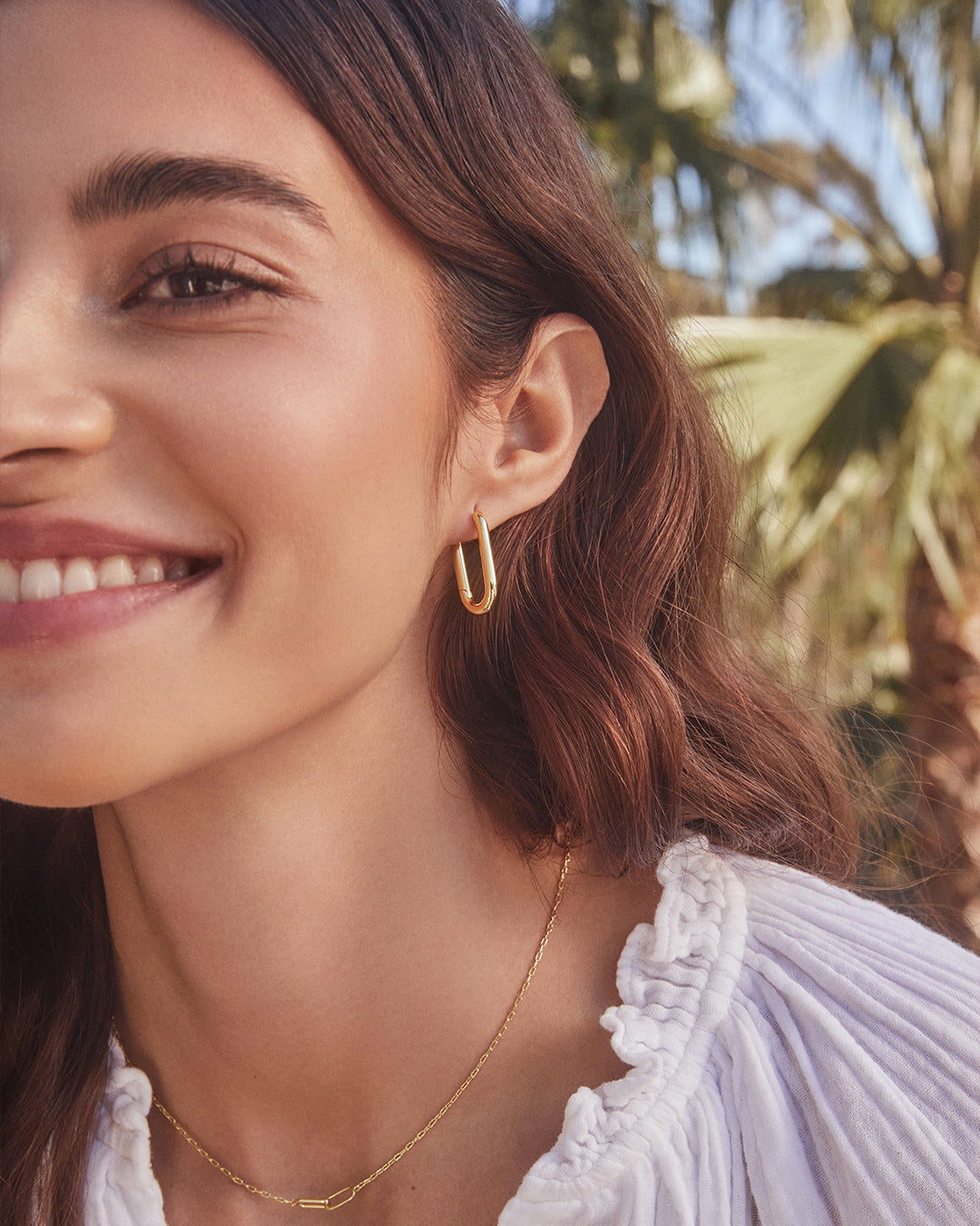 A pair of elegant gold plated paper clip hoop earrings with a 15/16" drop, showcasing a modern design.