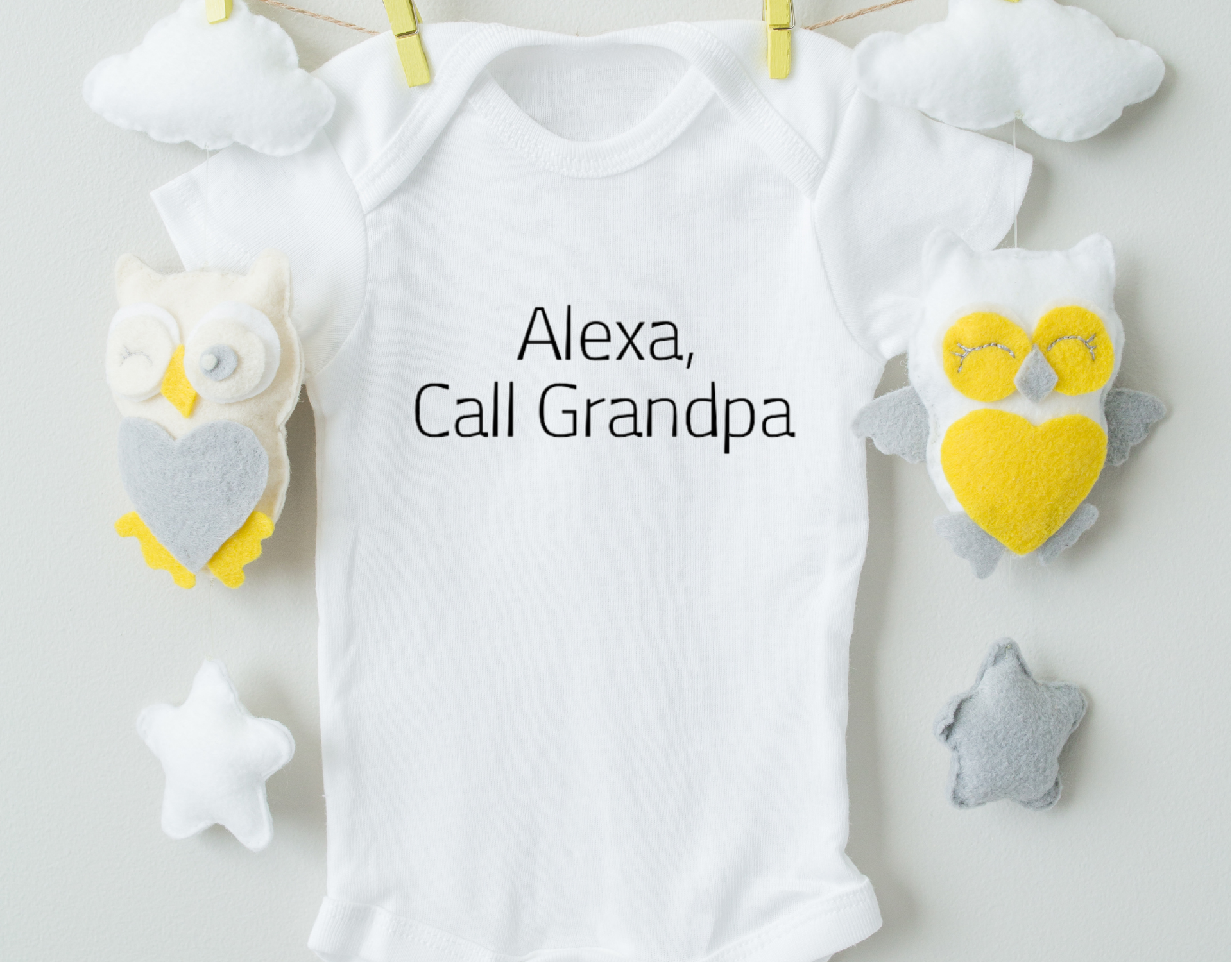 A cute cotton baby bodysuit with the phrase 'Alexa, Call Grandpa' printed on it, featuring an expandable neckline and snap closure.