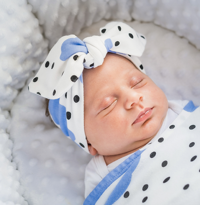 A soft blue clouds headband made from 100% GOTS organic cotton, designed for babies with an adjustable fit.