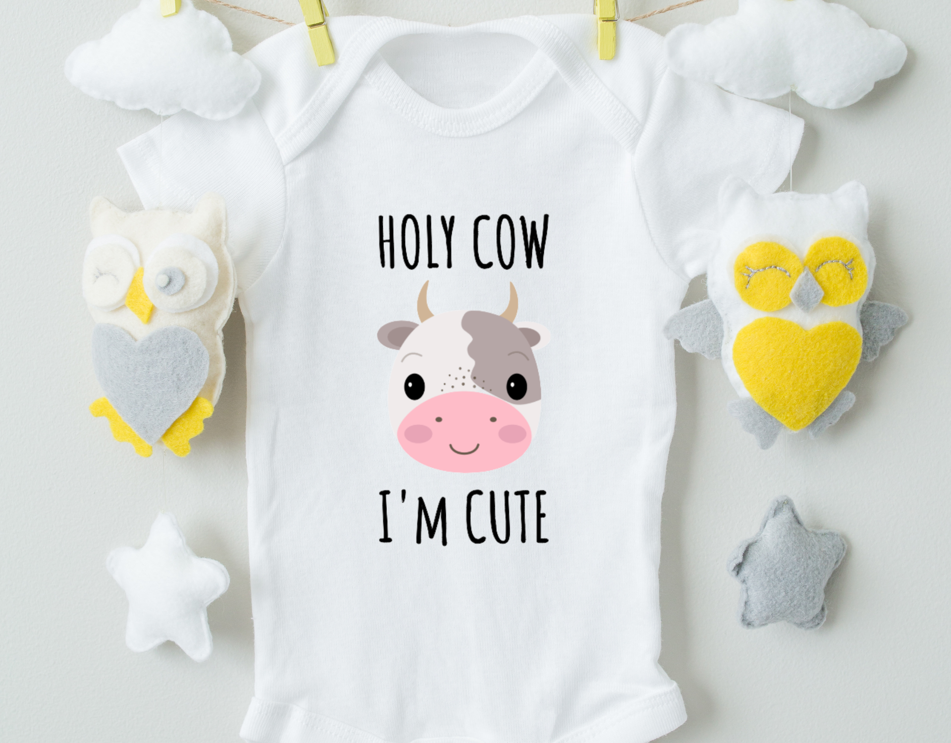 Holy Cow I'm Cute Cotton Baby Bodysuit in white with a cute design, featuring an expandable neckline and snap closure.