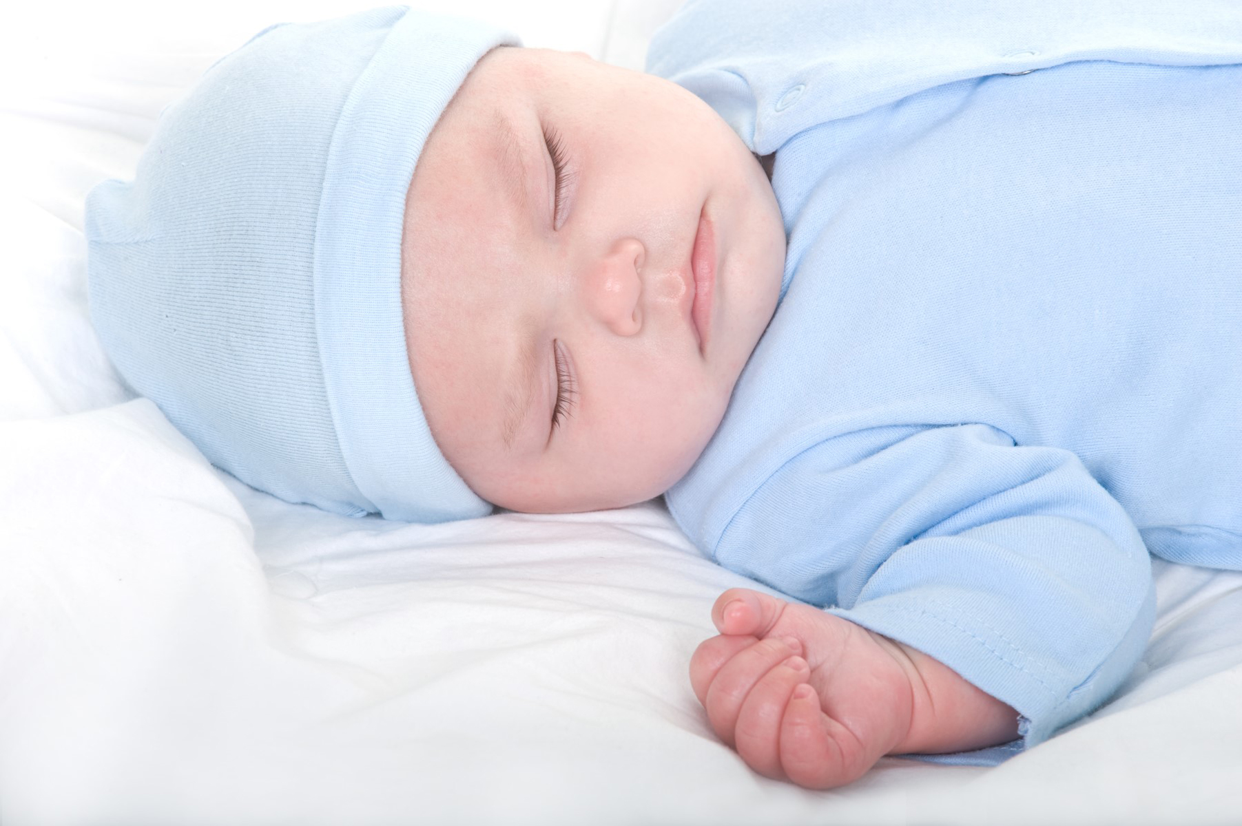 Newborn baby boys' layette set featuring soft cotton clothes and a blue baby cap, perfect for baby showers.