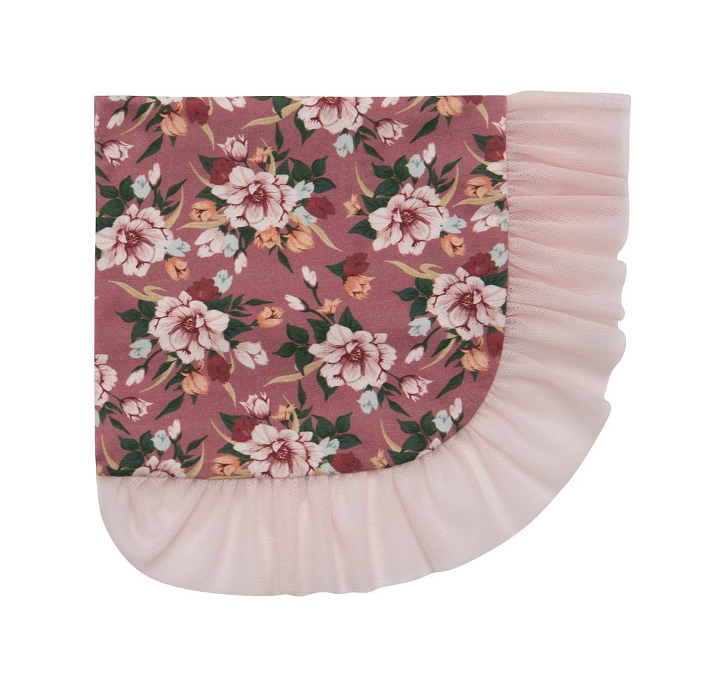 A cozy Sugar Plum Blanket draped over a couch, showcasing its soft texture and rich color.