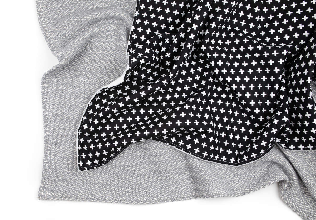 Lina Deluxe Crib Bedding Set featuring Swiss cross design in black and white with a grey weave blanket, perfect for modern nurseries.