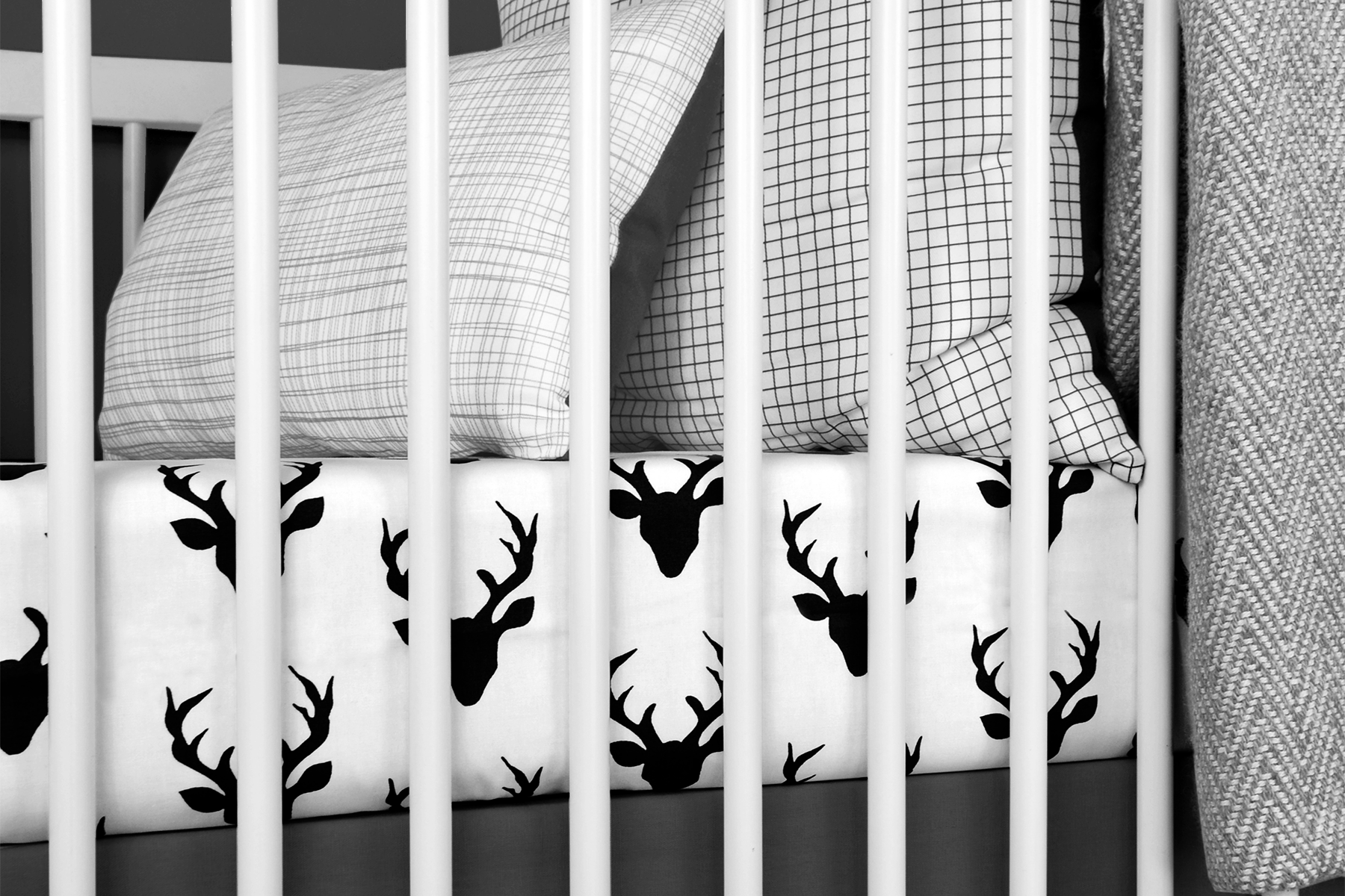 Mila Deluxe Crib Bedding Set featuring woodland deer design with grey weave blanket and charcoal crib skirt.