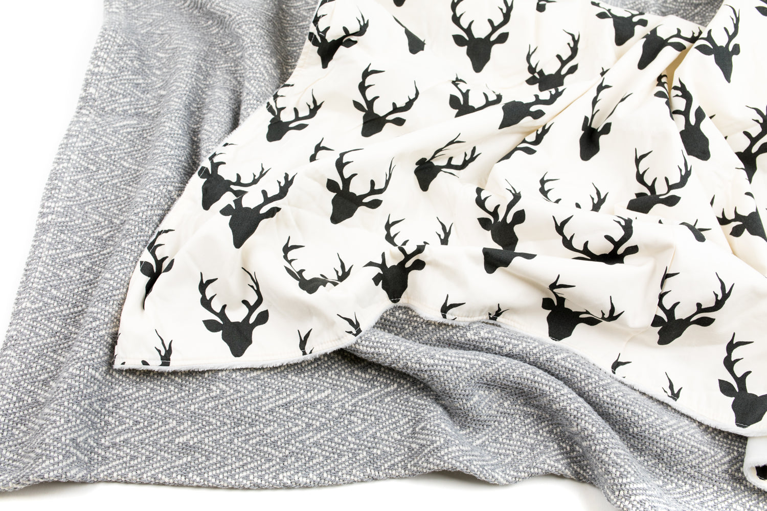 Mila Deluxe Crib Bedding Set featuring woodland deer design with grey weave blanket and charcoal crib skirt.