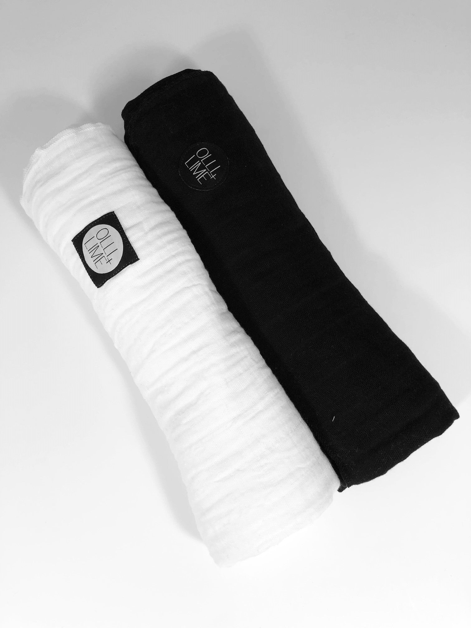 Two Pack of OLLI+LIME Swaddles in Black and White, showcasing luxurious cotton muslin fabric, perfect for modern nurseries.