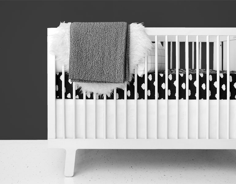 A crisp white crib skirt tailored for a standard crib, made from heavyweight cotton twill, enhancing nursery decor.