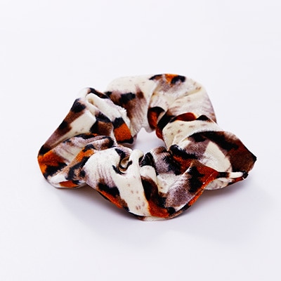 A stylish women's headwear made of soft coral fleece featuring a trendy leopard spot pattern, designed for comfort and a snug fit.