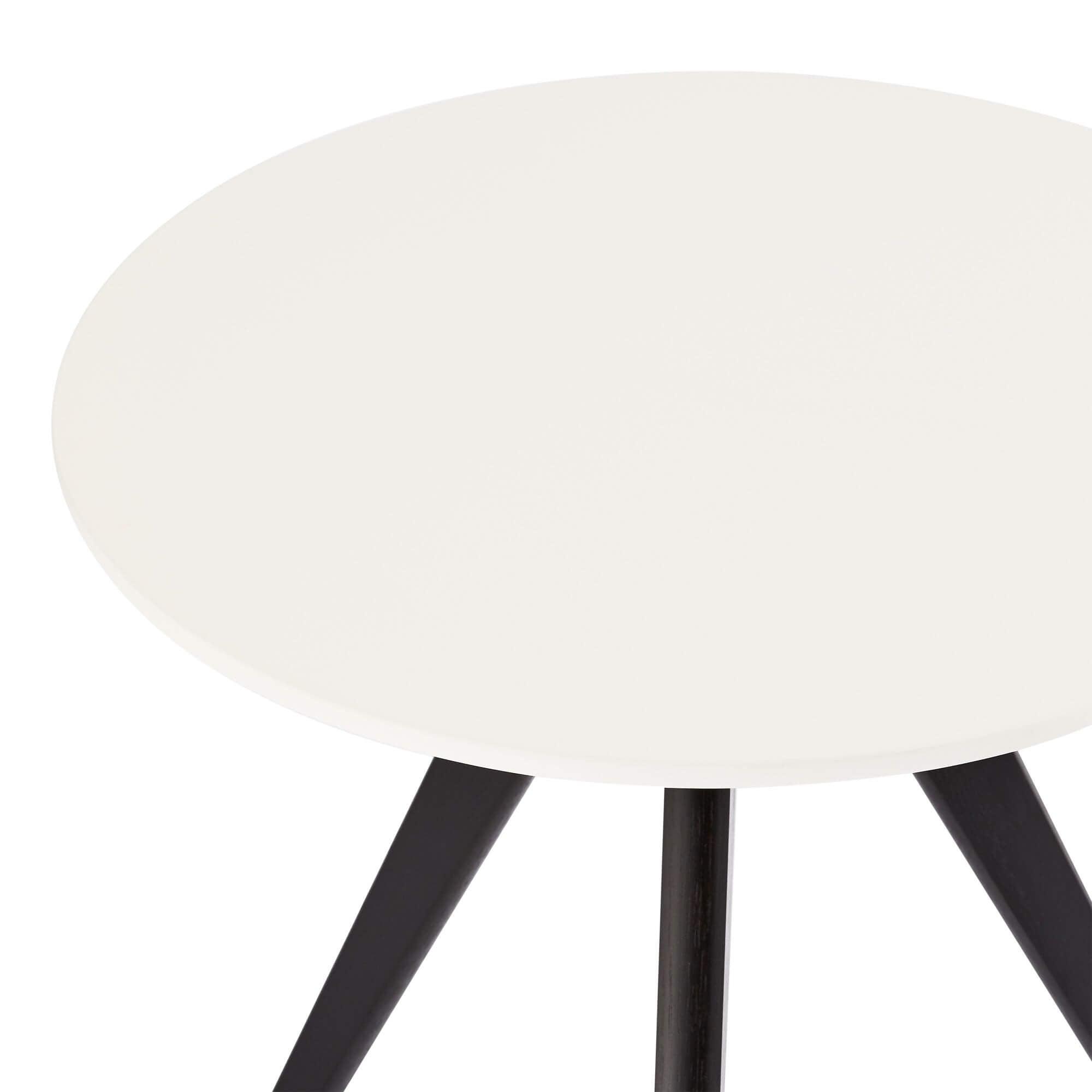 Round coffee table with white and black tabletop, featuring sturdy lacquered oak legs, designed for modern interiors.
