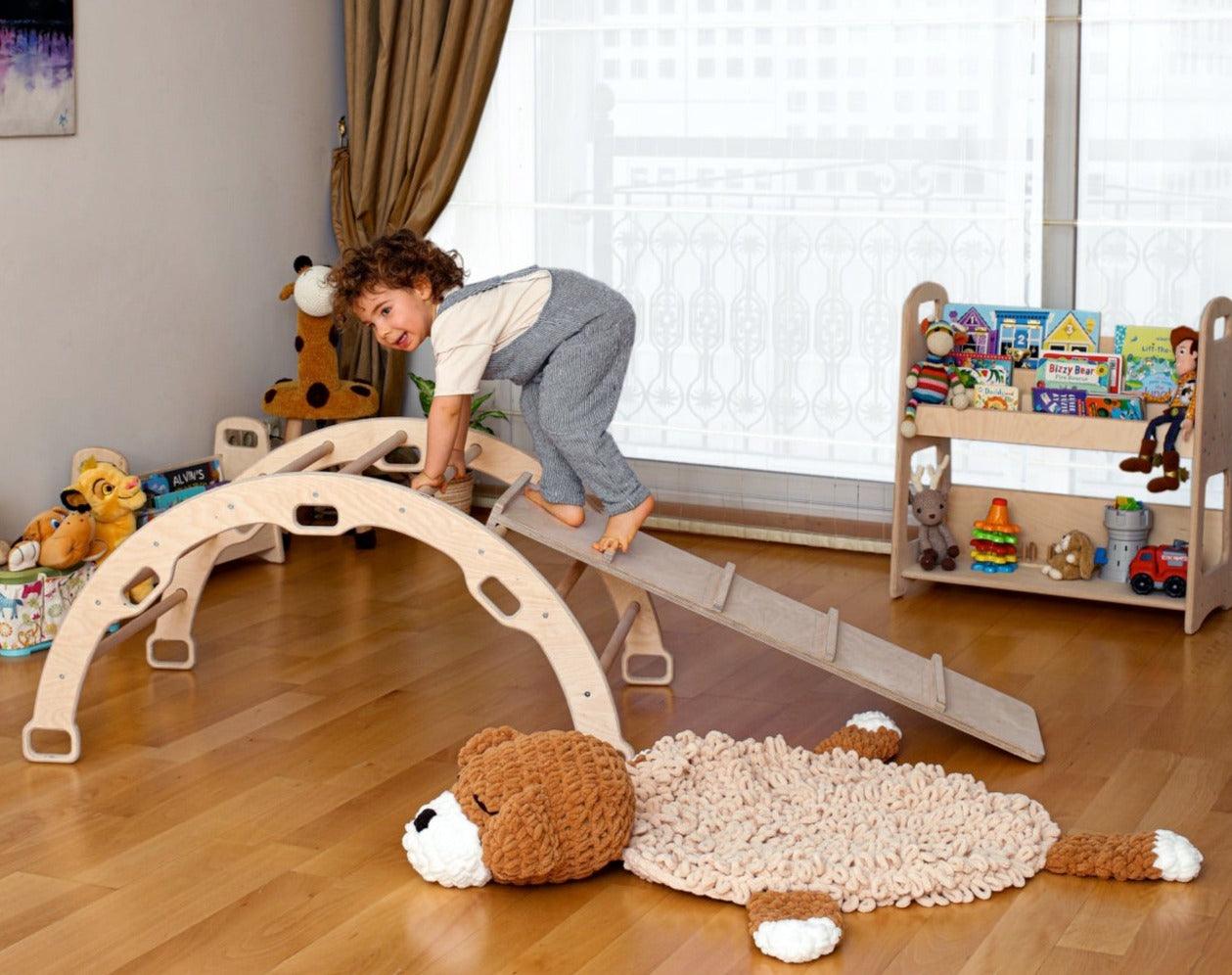 A wooden arch rocker with a ladder ramp, designed for children's play, featuring smooth edges and a sturdy construction for safety.