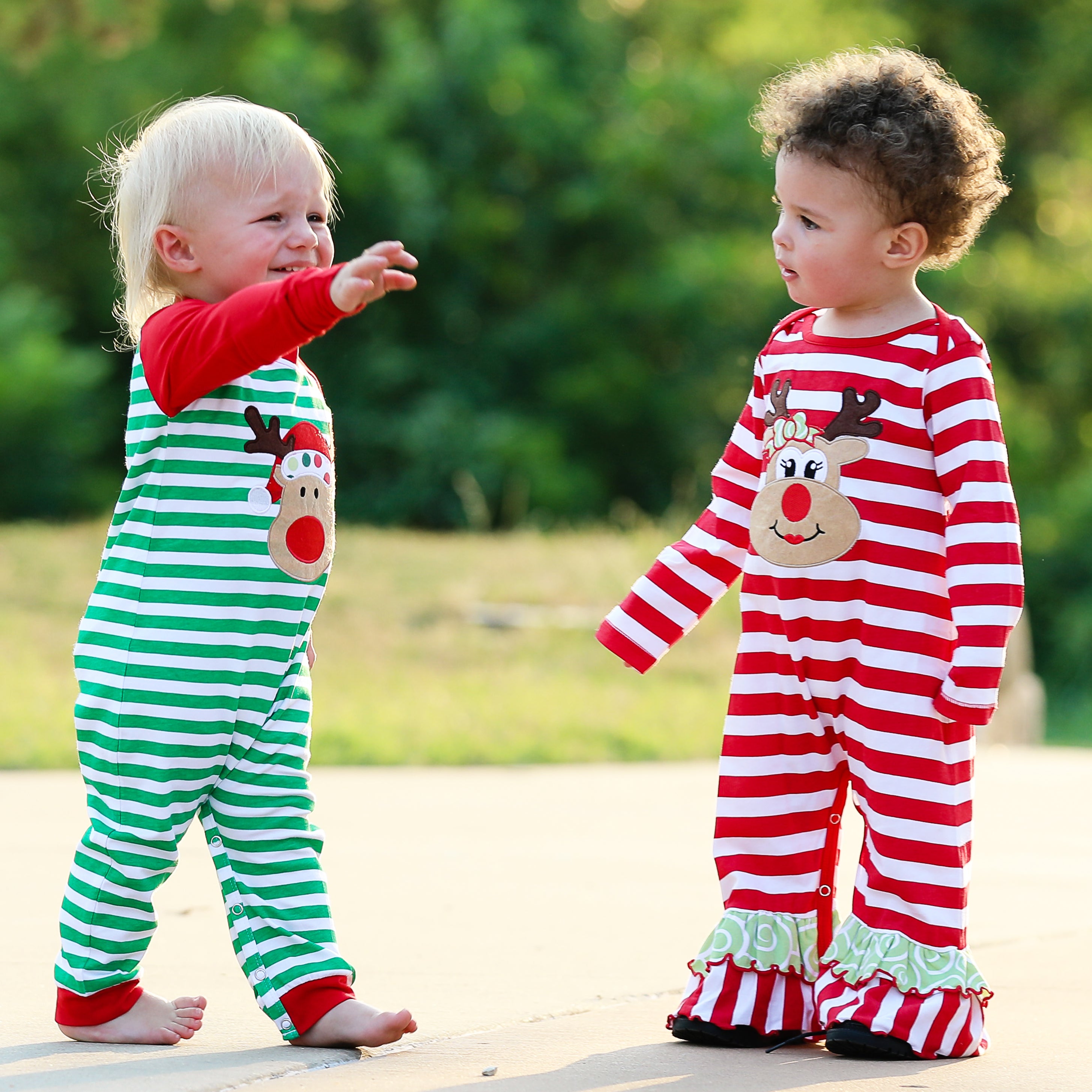AnnLoren Baby Toddler Girls Boutique Christmas Reindeer Romper featuring red and white stripes with green Christmas tree appliqué and ruffles.
