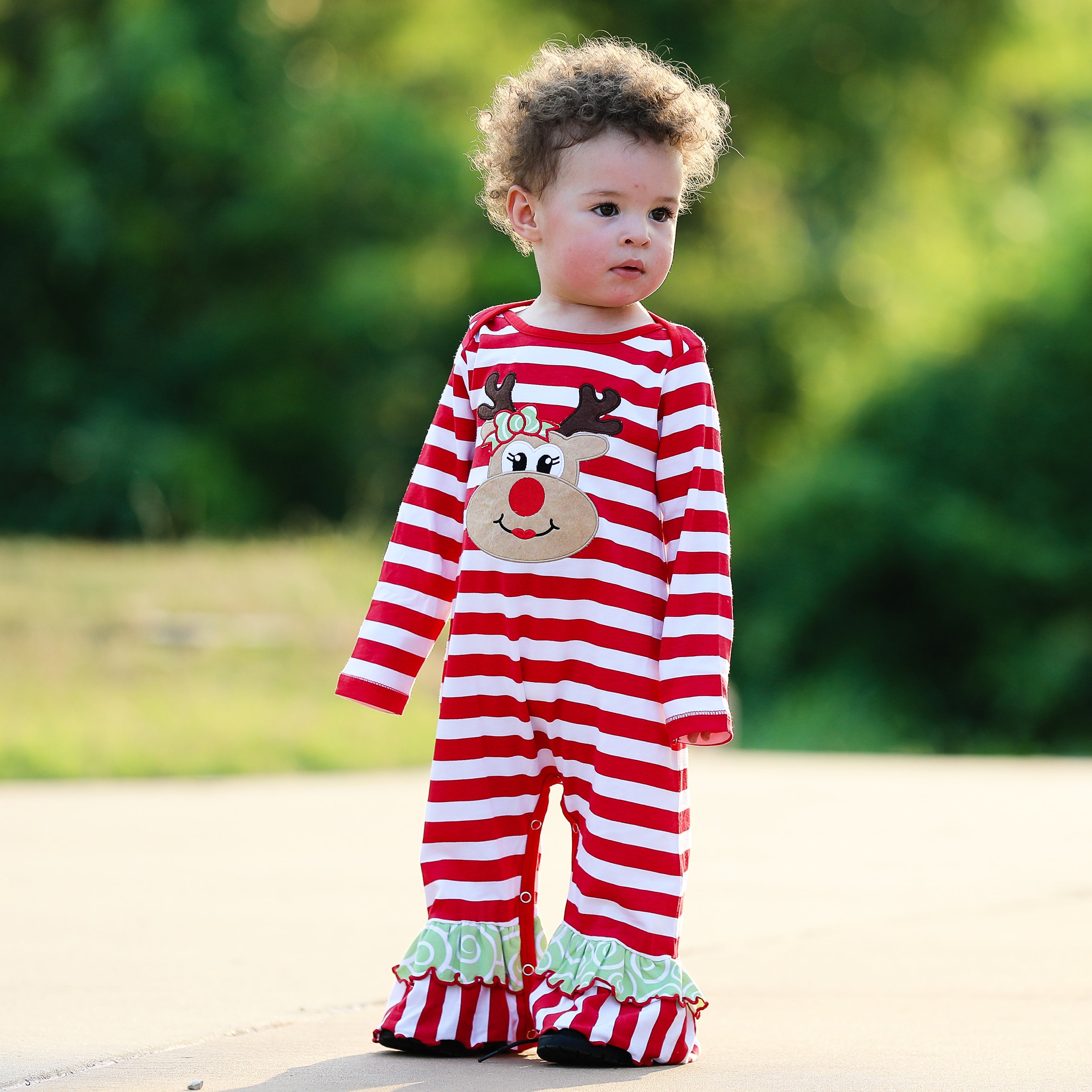 AnnLoren Baby Toddler Girls Boutique Christmas Reindeer Romper featuring red and white stripes with green Christmas tree appliqué and ruffles.