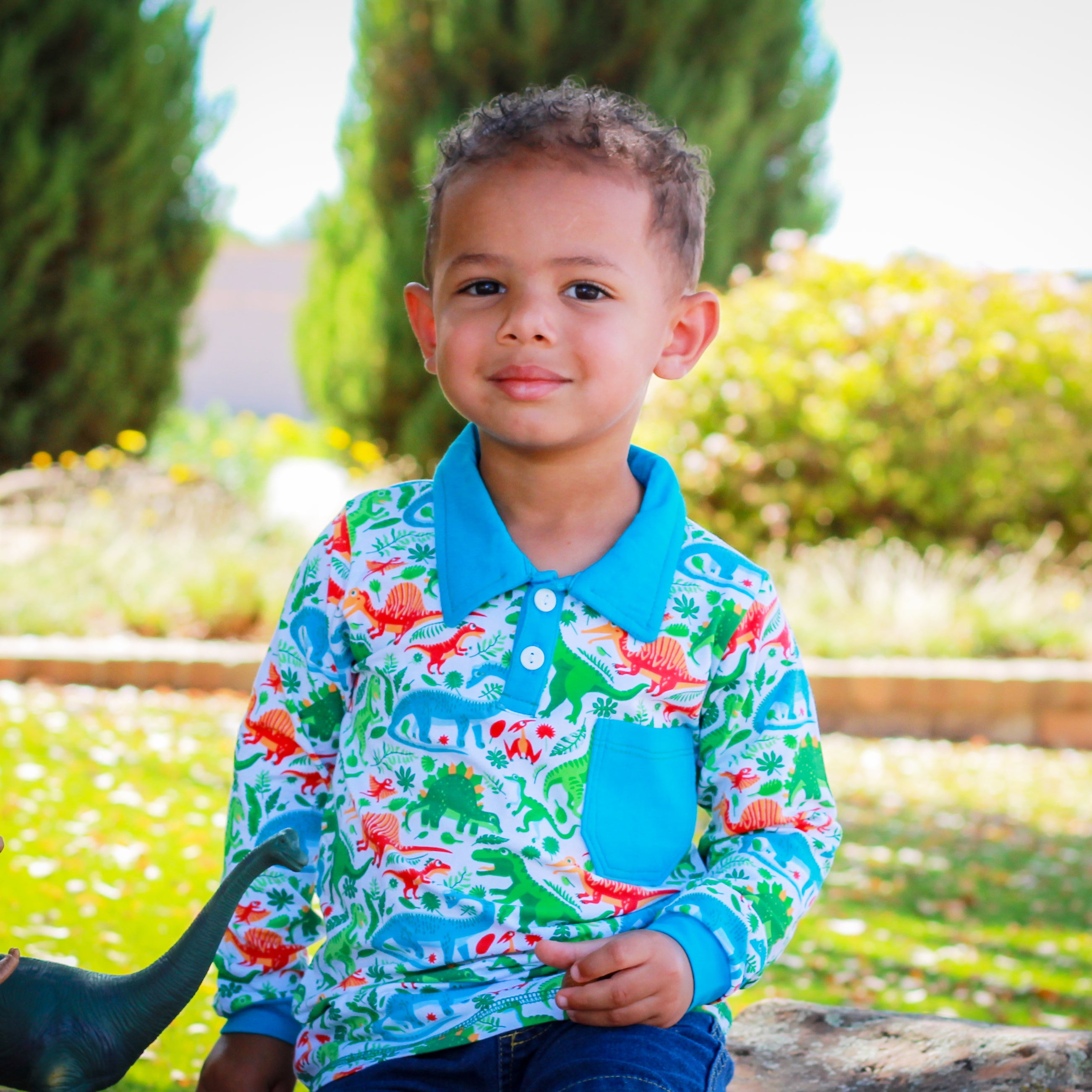 AnnLoren Toddler & Big Boys Long Sleeve Polo Shirt featuring a blue collar, pocket, and playful dinosaur print.