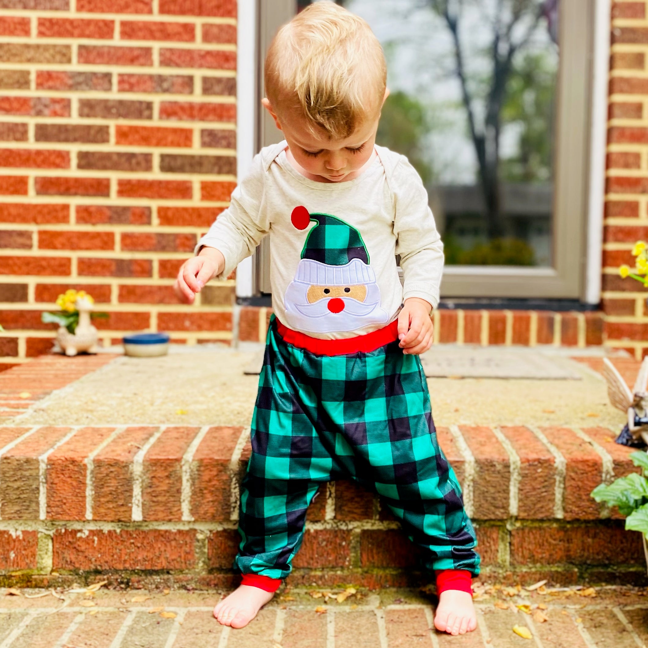 Baby boys holiday outfit featuring Santa Claus applique onesie and plaid jogger pants with red trim, perfect for Christmas celebrations.