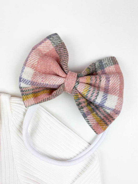 A cozy pink flannel 2 pc dress set for babies, featuring a big front bow and matching headband, perfect for winter wear.