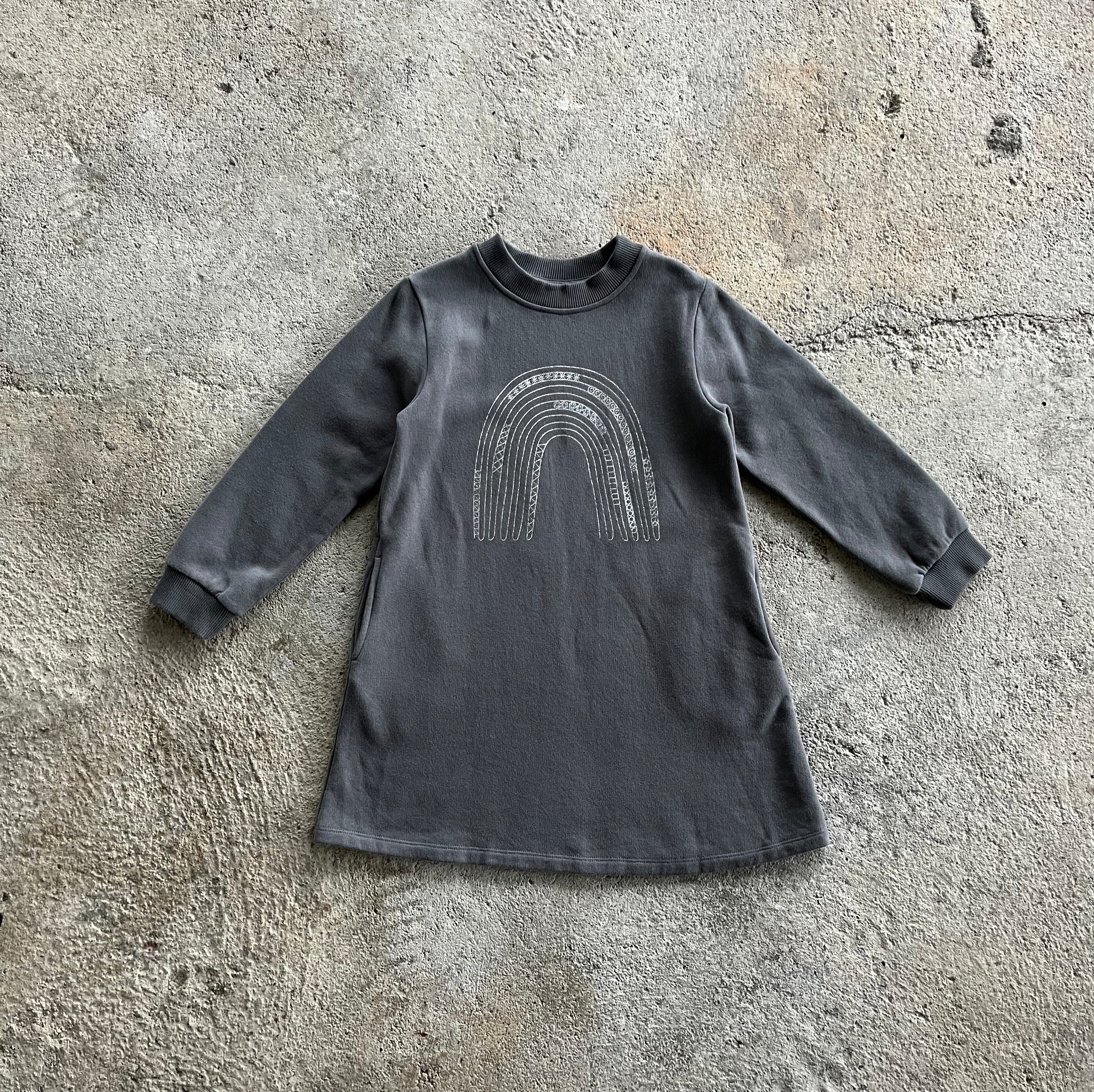 A stylish winter dress for girls in midnight grey, featuring long sleeves, a ribbed round collar, and side pockets, made from soft brushed cotton fleece.