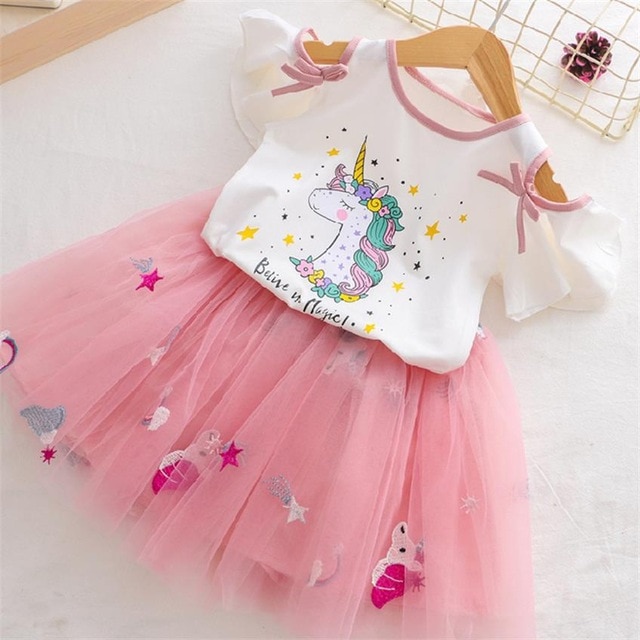 Pink unicorn-themed dress on hanger.