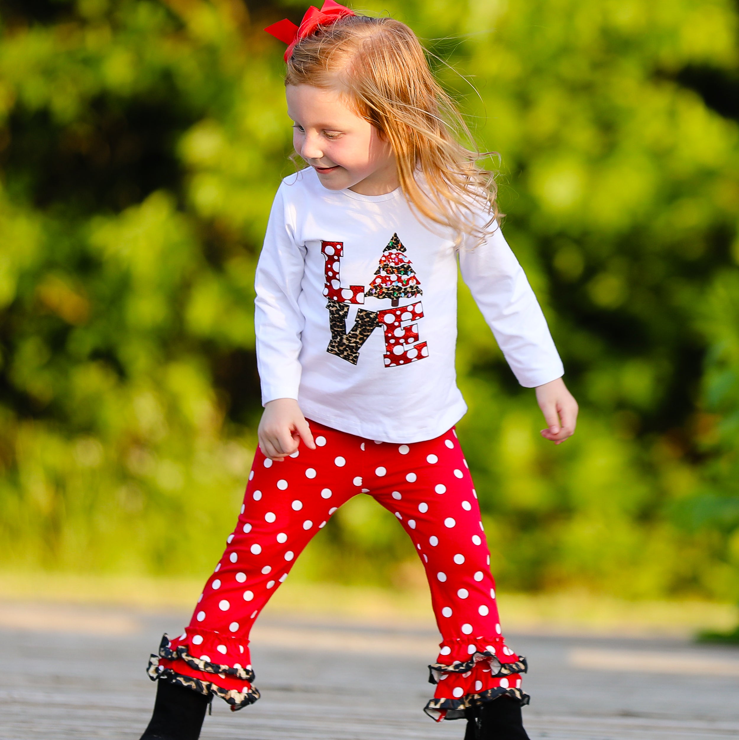 Girls LOVE Christmas outfit featuring a top with LOVE applique and red polka dot ruffle pants, perfect for festive occasions.