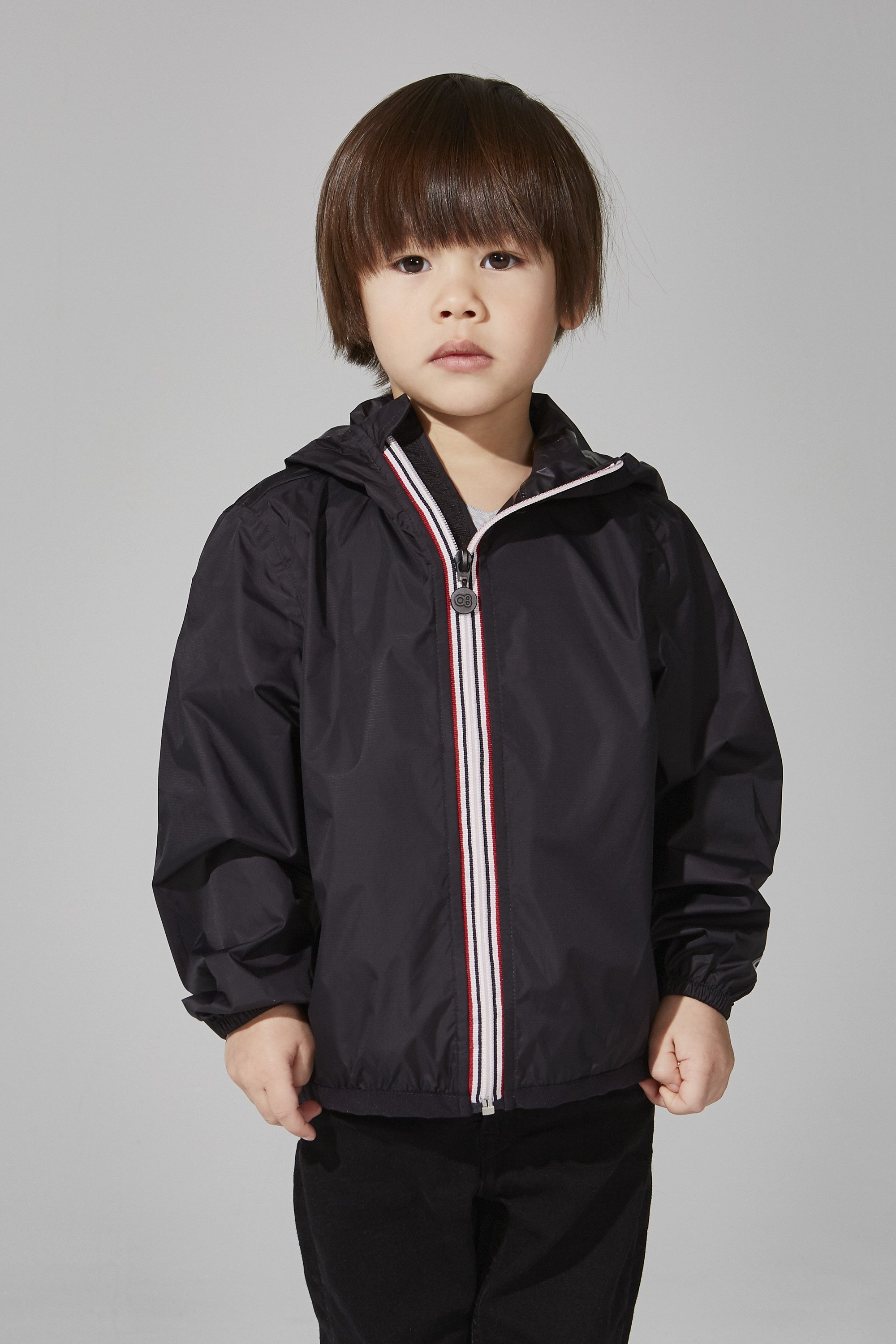 Kids Black Full Zip Packable Rain Jacket displayed on a hanger, showcasing its sleek design and packable feature.