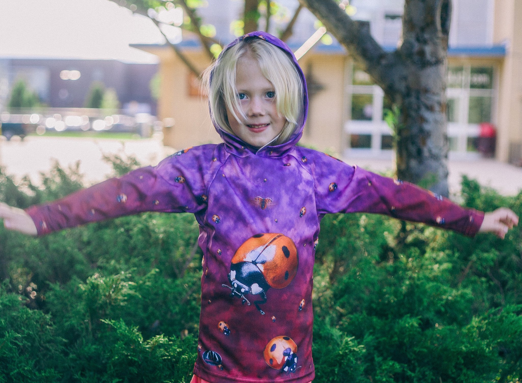 A vibrant LADYBUG Hoodie Chomp Shirt featuring colorful ladybug designs on a soft, lightweight fabric, perfect for outdoor activities.